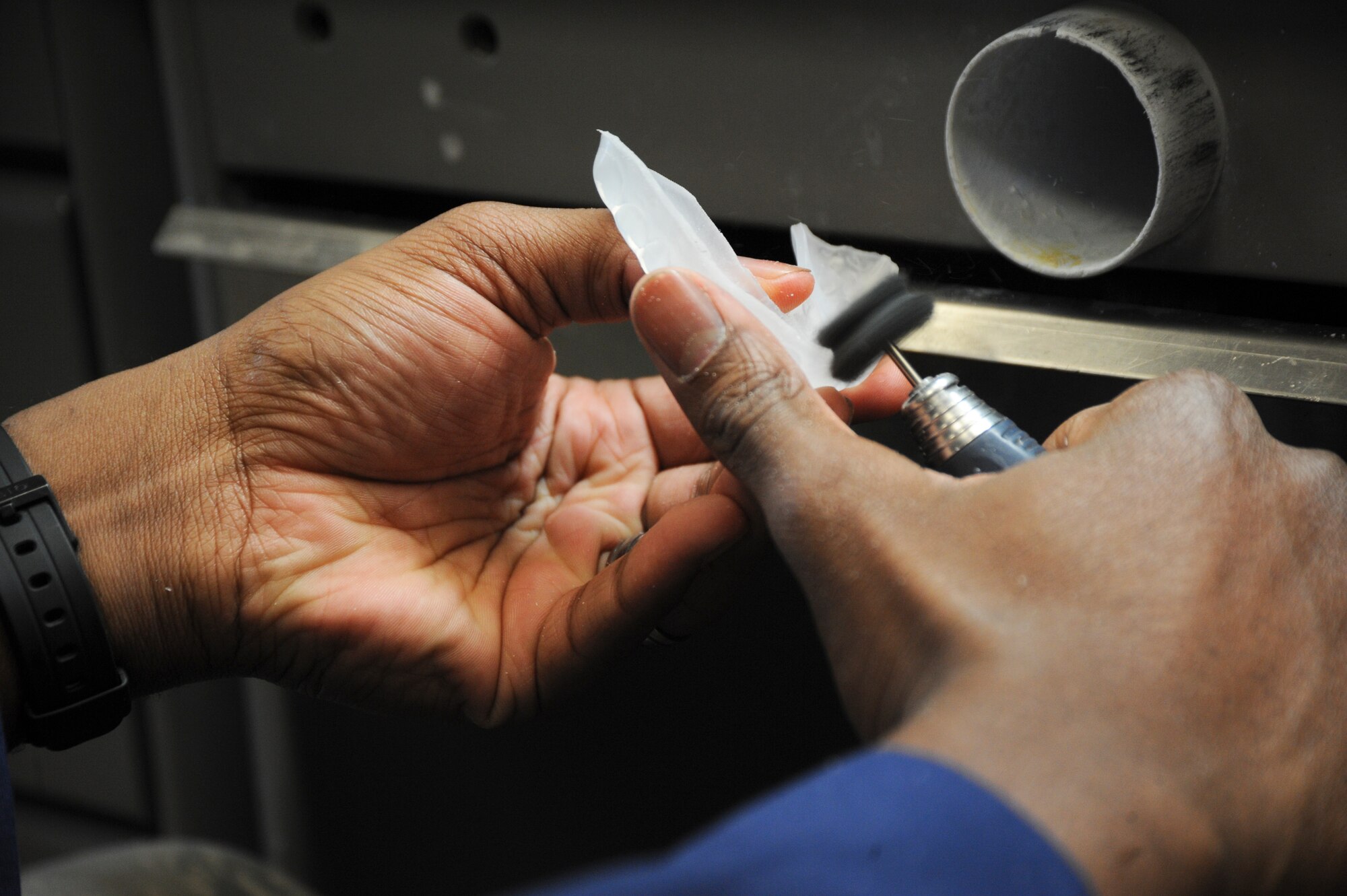 U.S. Air Force Senior Airman Tarell Walker, 355th Medical Group dental laboratory technician, smooths out the edges of a mouth guard at Davis-Monthan Air Force Base, Ariz., Oct. 24, 2013. New findings in sports dentistry show that even non-contact sports such as skateboarding, gymnastics, and biking could cause potential injury to the mouth. (U.S. Air Force Senior Airman Sivan Veazie/Released)
