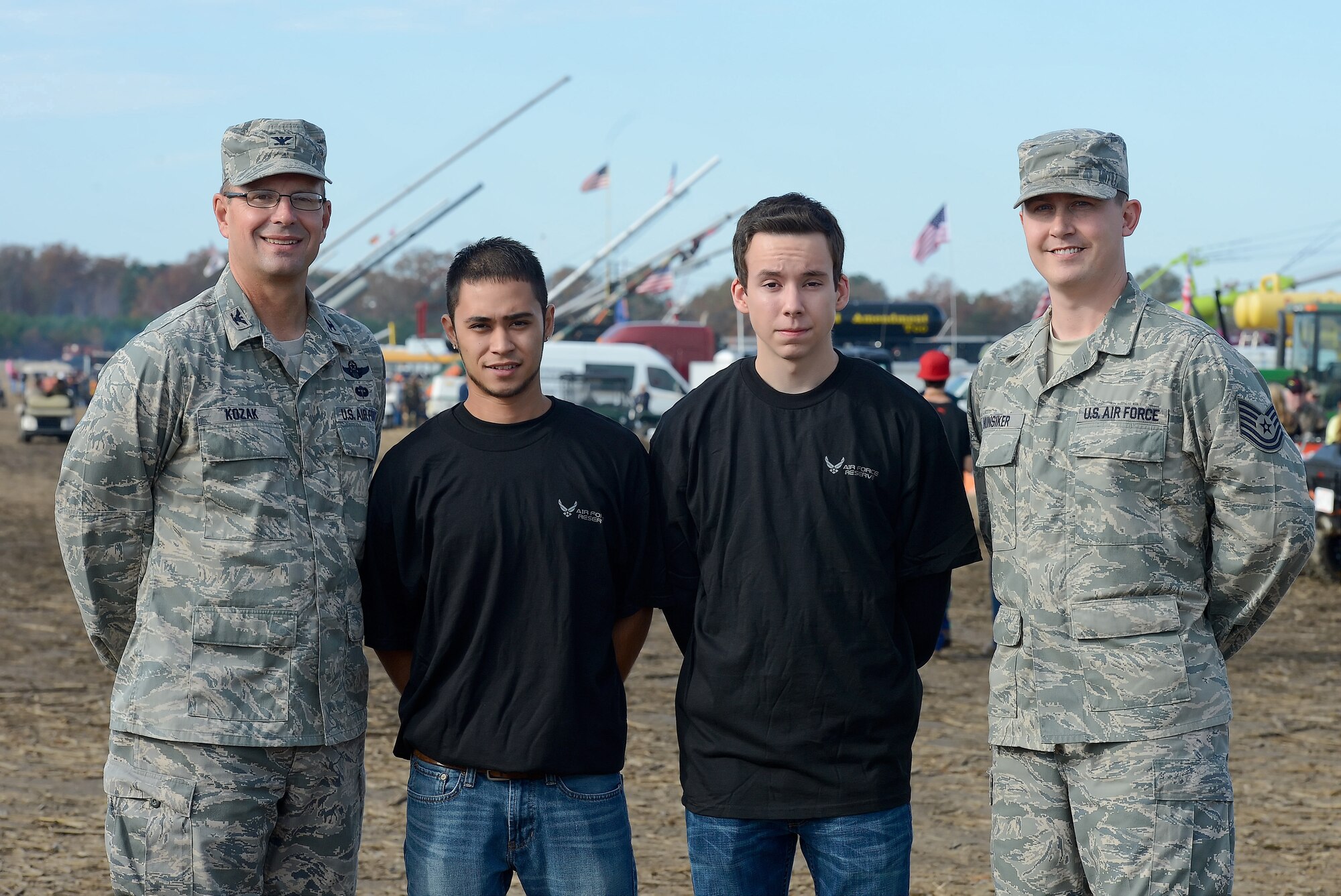 Col. Raymond A. Kozak (left), the 512th Airlift Wing commander at Dover Air Force Base, Del., along with two new recruits and a reservist who re-enlisted, pause for a snapshot in front a line of raised air cannons following an enlistment ceremony at the World Championship Punkin Chunkin event in Bridgeville, Del., Nov. 2, 2013. Air Force Reserve recruit Anthony Green (middle left) is slated to become an aerial port specialist and Zachary Ellis enlisted as a C-5M loadmaster. Tech. Sgt. Christopher Hunsiker, a logistics plans technician, signed-up for six more years. (Courtesy photo by Greg L. Davis)