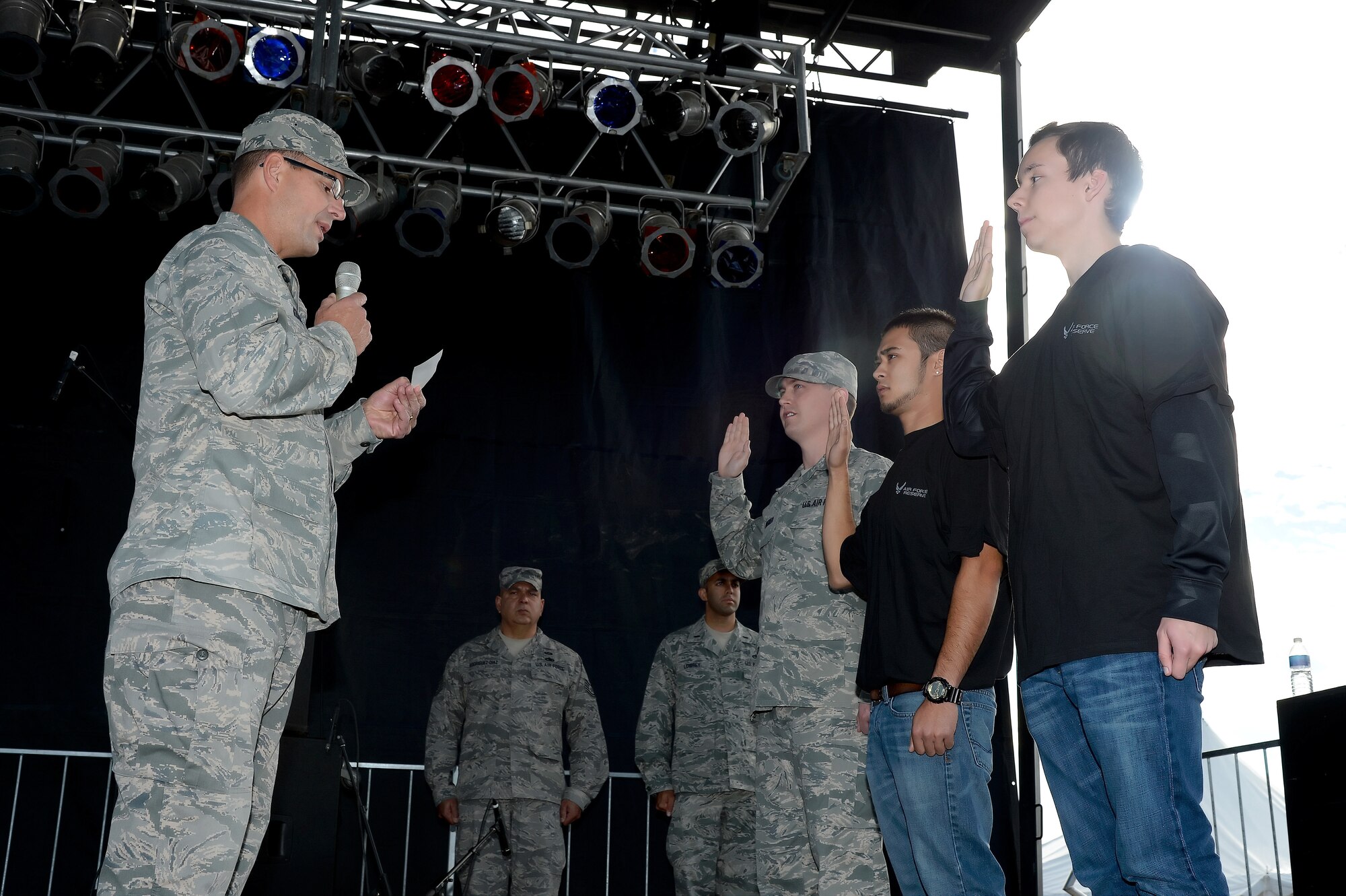 Col. Raymond A. Kozak (left), the 512th Airlift Wing commander at Dover Air Force Base, Del., administers the oath of enlistment to two new recruits and one reservist re-enlistee as part of the World Championship Punkin Chunkin Opening Ceremony in Bridgeville, Del., Nov. 2, 2013. The 512th AW, the only Air Force Reserve unit in Delaware, is actively hiring new people to meet a new recruiting goal to increase the size of the unit to more than 1,900 members. (Courtesy photo by Greg L. Davis)