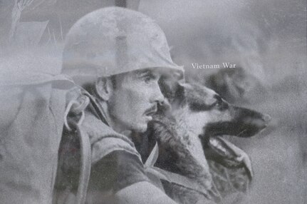 A image of a handler with his dog during the Vietnam War was part of collection that create a montage that is etched onto the face of the wall at the Military Working Dog Teams’ National Monument which was revealed Oct. 28, 2013 at Joint Base San Antonio-Lackland, Texas. There was also a statue of an Airman that was accompanied by four dog statues. (U.S. Air Force photo by Airman 1st Class Krystal M. Jeffers/Released)