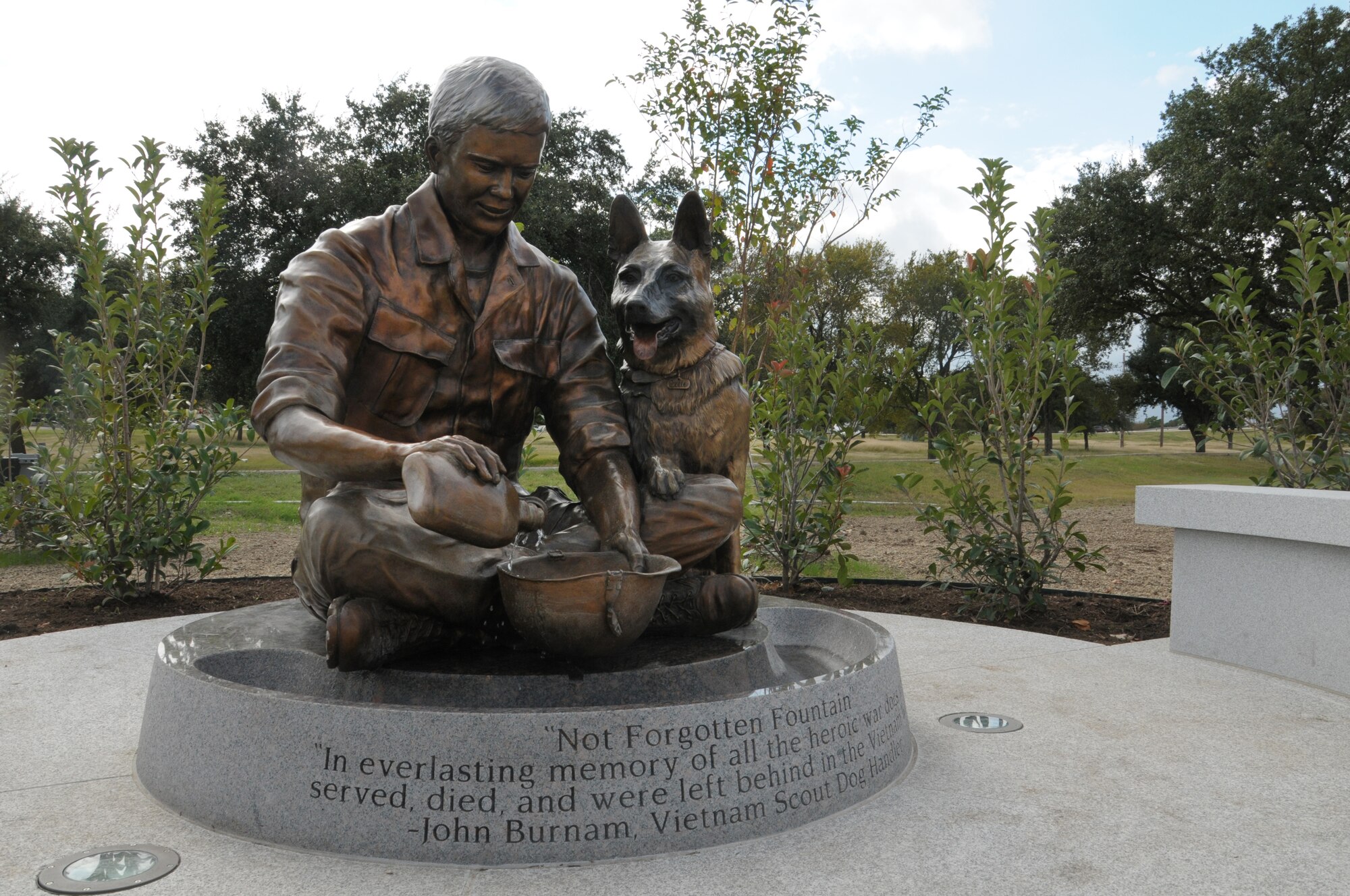 The Military Working Dog Teams’ National Monument, which includes a statue of a handler with his dog, was revealed Oct. 28, 2013 at Joint Base San Antonio-Lackland, Texas. There was also a wall with a montage of images of handlers with their canines and a statue of an Airman that was accompanied by four dog statues. (U.S. Air Force photo by Airman 1st Class Krystal M. Jeffers/Released)