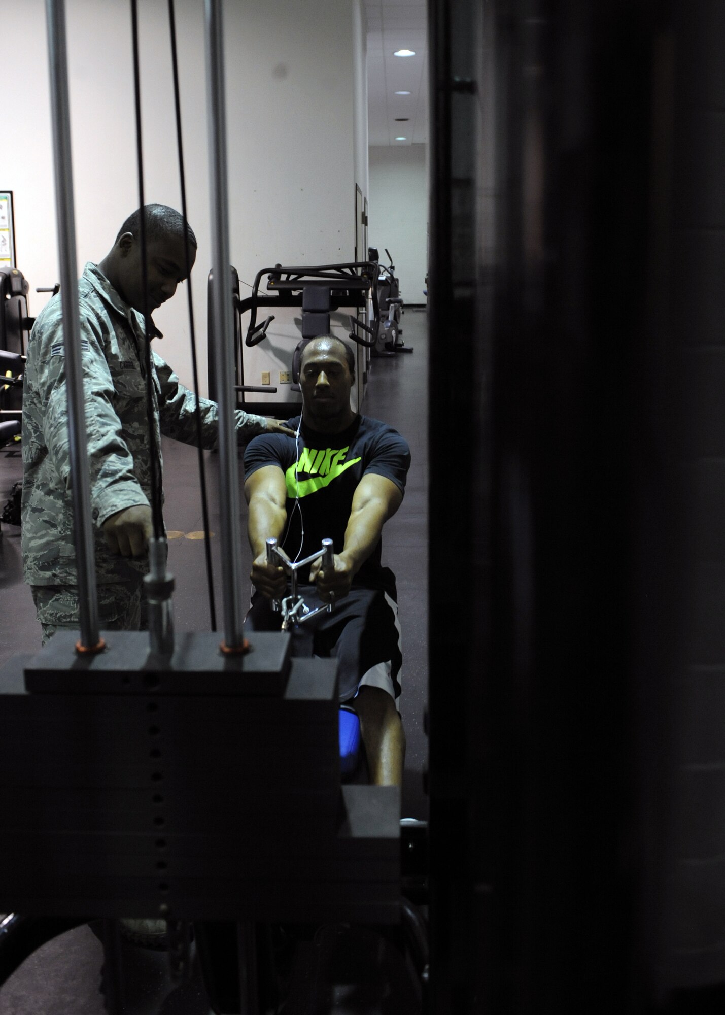 U.S. Air Force Senior Airman Damon Carrol, left, 7th Force Support Squadron, shows Senior Airman Anthony Steele, 7th Operations Support Squadron, how to properly use the cable row machine Oct. 30, 2013, at the fitness center on Dyess Air Force Base, Texas. Teaching Airmen how to properly use equipment helps them get the most out of their workout and prevents them from injuring themselves. (U.S. Air Force photo by Senior Airman Shannon Hall/Released)