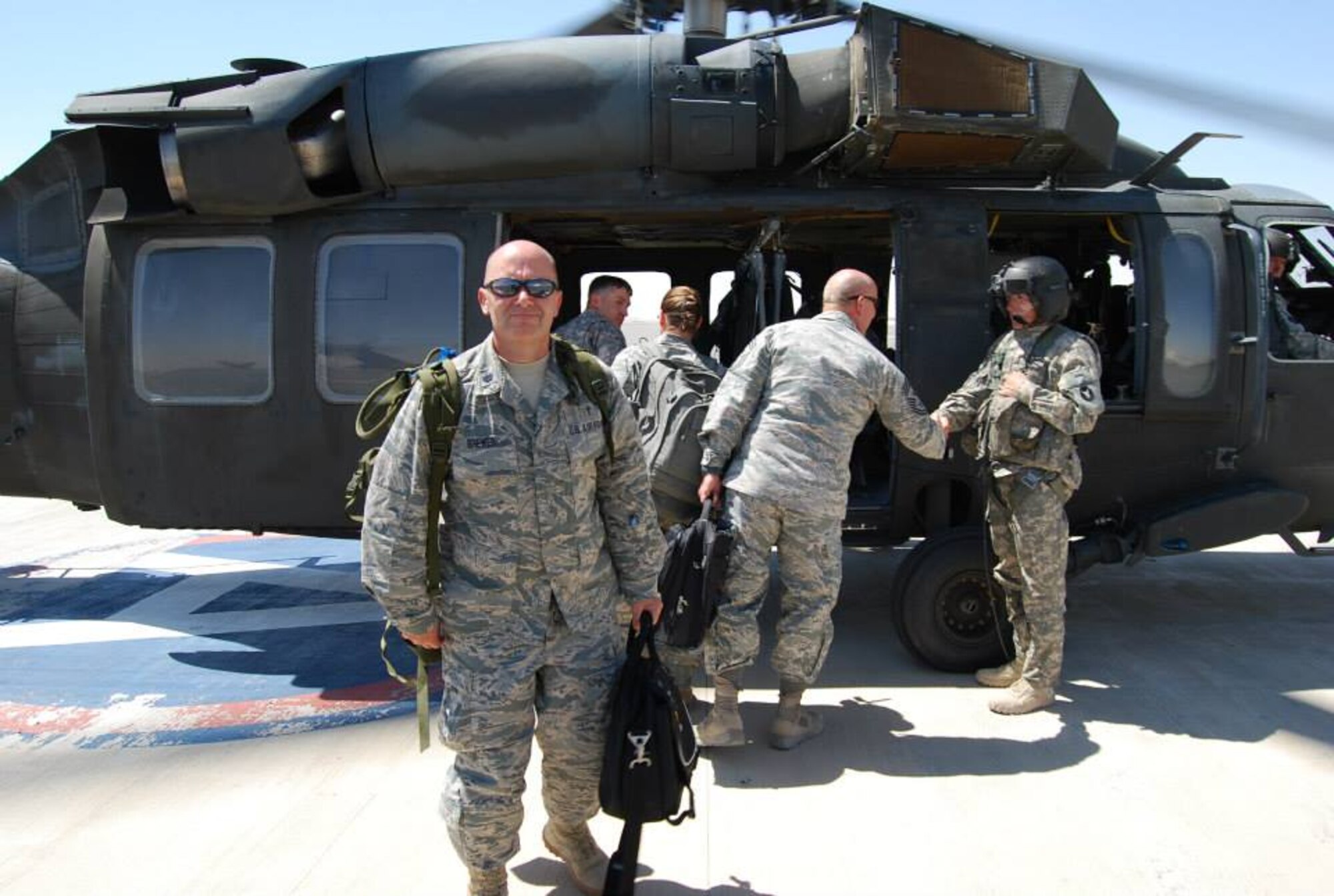 U.S. Air Force Chaplain (Lt. Col.) Bruce Brewer, 380th Air Expeditionary Wing chaplain, poses for a photo in front of a helicopter at an undisclosed location in Southwest Asia. During his deployment, Brewer traveled with the commander to various sites of geographically seperated units under the 380th AEW. (Courtesy photo)