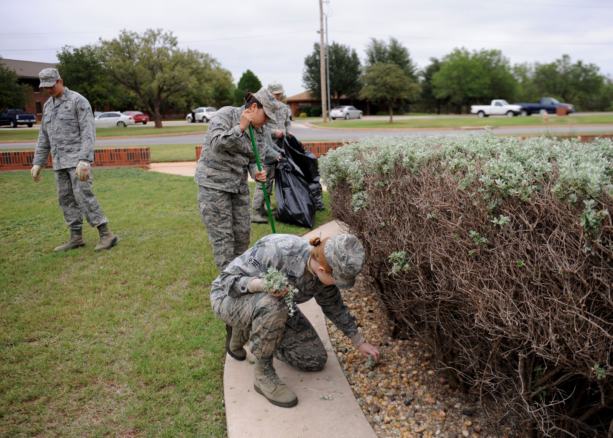 Airmen who work in the 7th Bomb Wing Headquarters building pick up weeds and trash Oct. 18, 2013 at Dyess Air Force Base, Texas. They spent around three hours picking up trash and weeds, mowing and edging the lawn and trimming bushes. This event was organized by the 7th Bomb Wing Command Chief, Chief Master Sgt. Eddie Webb as a team building event to bring Airmen together to enhance their workcenter and to encourage others to take pride in theirs.. (U.S. Air Force photo by Airman 1st Class Autumn Velez/Released)