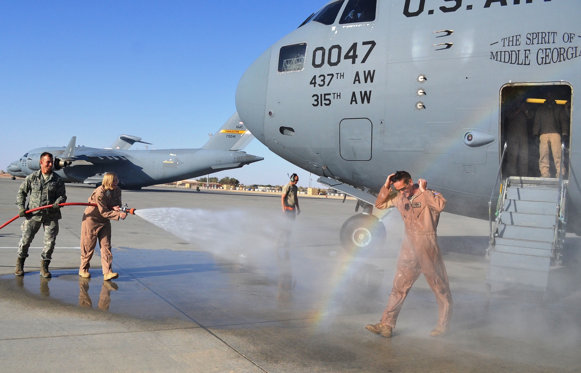 U.S. Air Force Lt. Col. Erin Stainepyne sprays down U.S. Air Force Lt. Col. Stephen Clements, 817th Expeditionary Airlift Squadron C-17 Globemaster III pilot, after his 10,000 flight hour mission at an undisclosed location in Southwest Asia Oct. 20, 2013. Clements is deployed from the 313th Airlift Squadron out of Joint Base Lewis-McChord, Wash. (U.S. Air Force photo by Staff Sgt. Ashley Long)