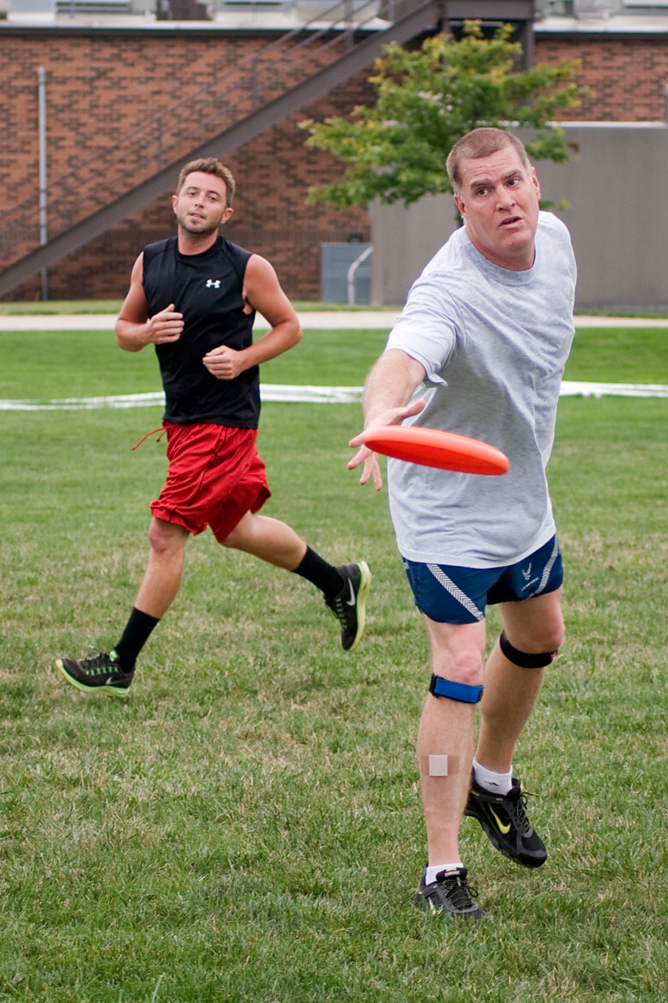 Mark Copp lets a disc fly as Brian Wright watches on during a game of ultimate at Grissom Air Reserve Base, Ind., Aug. 8. 2013. Copp is a 434th Operations Support Squadron combat crew communications superintendent, and Wright is a Grissom combat readiness technician. (U.S. Air Force photo/Tech. Sgt. Mark R. W. Orders-Woempner)