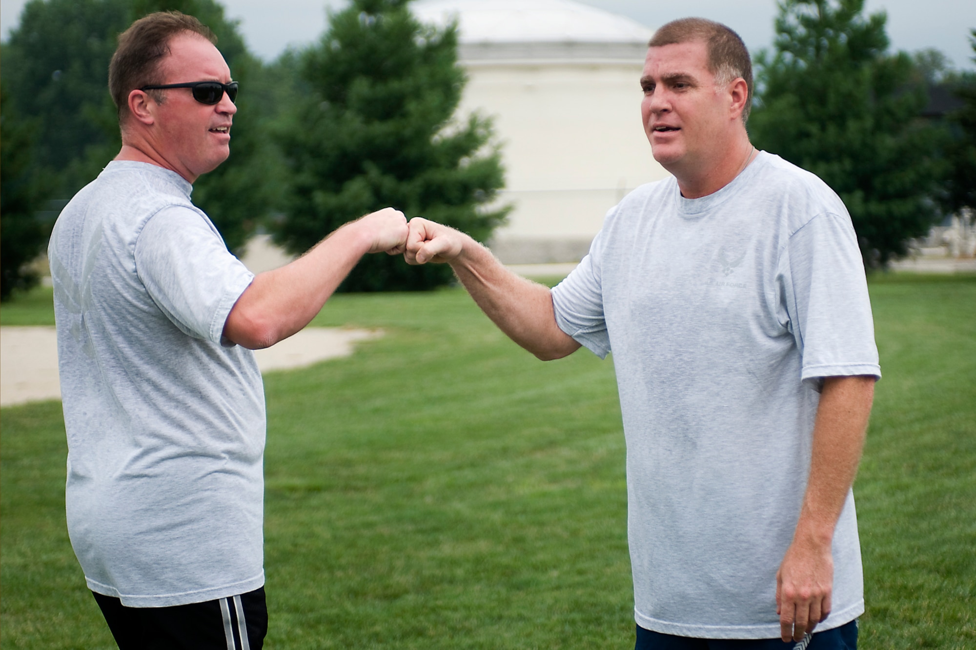 From left to right, Joe Austin Jr. and Mark Copp fist bump during a game of ultimate at Grissom Air Reserve Base, Ind., Aug. 8. 2013. Copp is a 434th Operations Support Squadron combat crew communications superintendent, and Austin is a 434th OSS chief of current operations. (U.S. Air Force photo/Tech. Sgt. Mark R. W. Orders-Woempner)