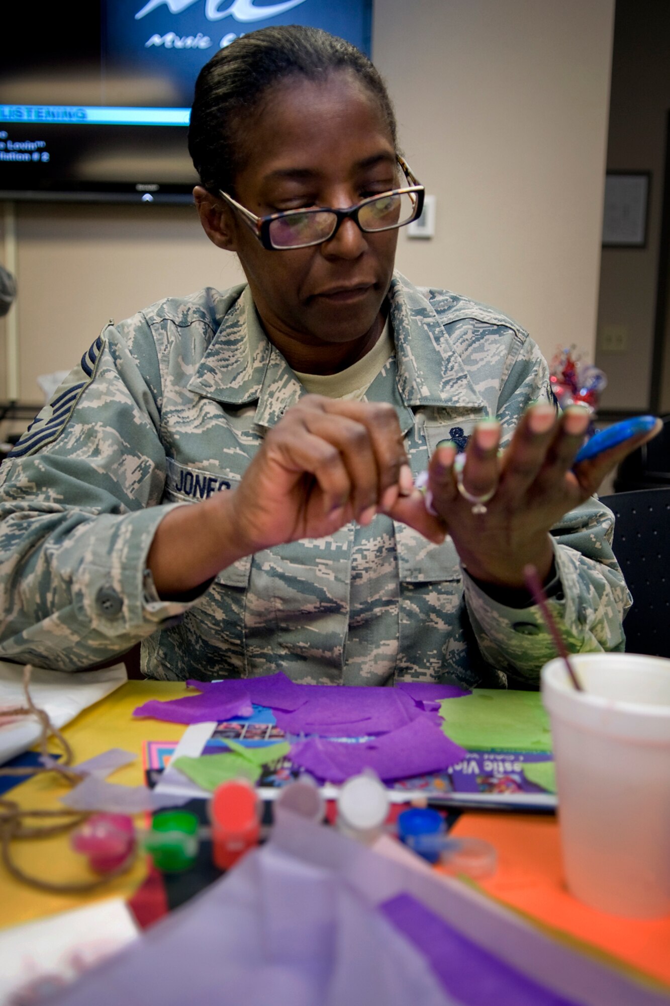 Chief Master Sgt. Tamara Jones, 434th Logistics Readiness Squadron superintendent, uses tissue paper and feathers to decorate her hand during a Domestic Violence Awareness Month activity at Grissom Air Reserve Base, Ind., Oct. 17, 2013. Grissom personnel took time to decorate their hands as a way to show their support for ending domestic violence. (U.S. Air Force photo/Tech. Sgt. Mark R. W. Orders-Woempner) 
