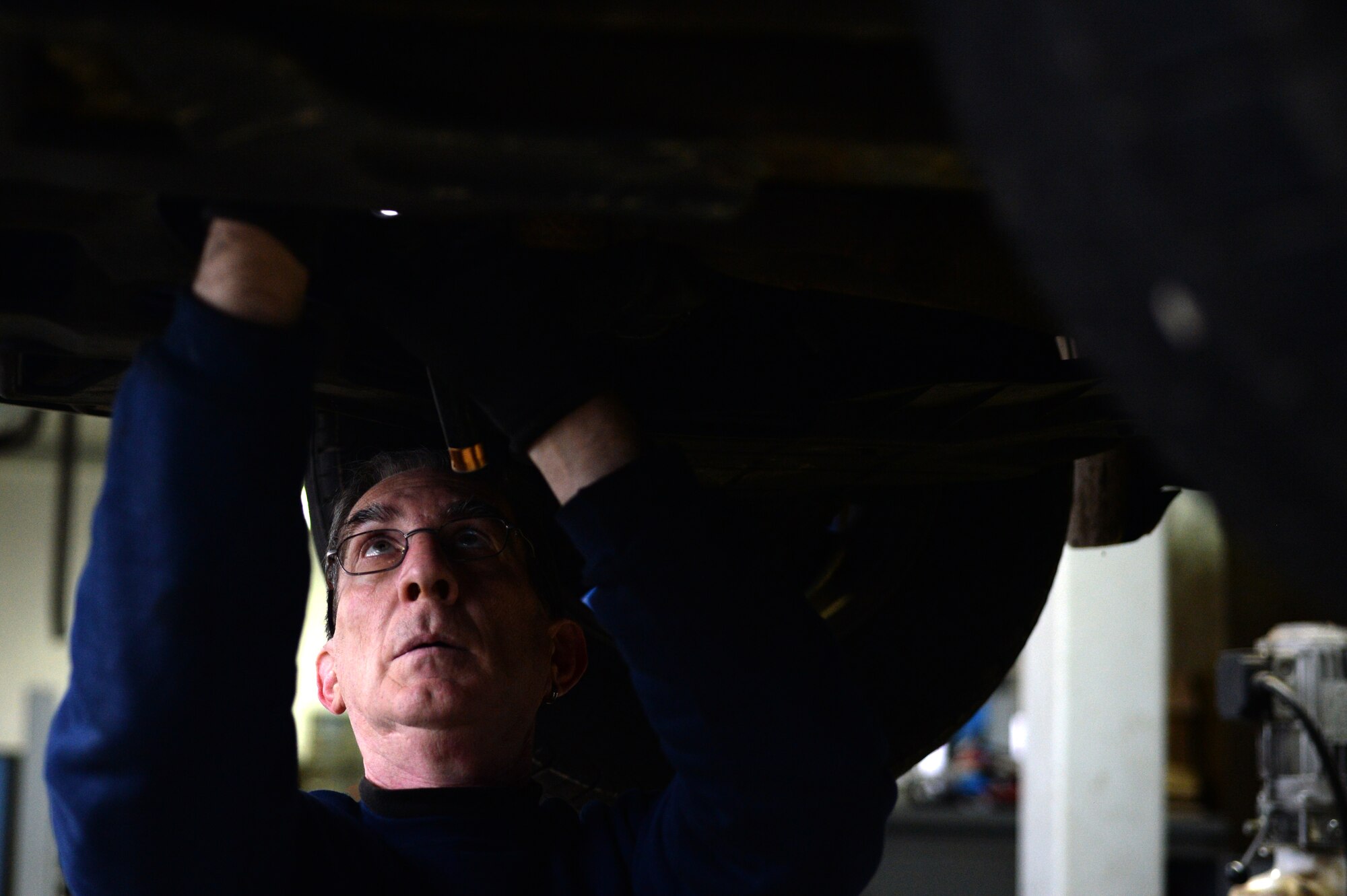 SPANGDAHLEM AIR BASE, Germany — Mike Adamoyurka, 52nd Force Support Squadron Auto Hobby Center mechanic, investigates a wiring problem on a 2003 Kia Sedona Nov. 7, 2013. Adamoyurka has more than 30 years of experience working on vehicles, 21 of which were served in the Air Force. (U.S. Air Force photo by Senior Airman Alexis Siekert/Released)