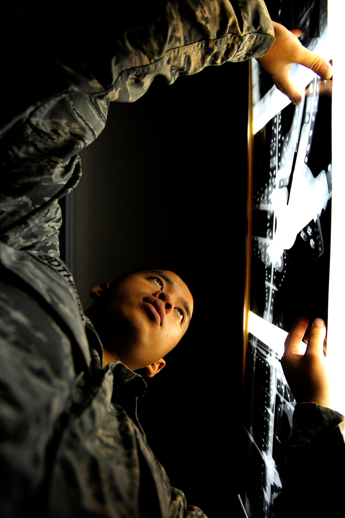 U.S. Air Force Senior Airman Charles Sothikhoun, 18th Equipment Maintenance Squadron Nondestructive Inspection technician, hangs up an aircraft X-ray at the NDI shop on Kadena Air Base, Japan, Nov. 5, 2013. NDI uses multimillion-dollar equipment from an X-ray machine to a special dye that glows under a black light to inspect the integrity of roughly 500 parts a month. (U.S. Air Force photo by Senior Airman Maeson L. Elleman)