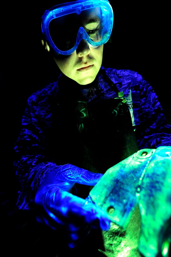 U.S. Air Force Staff Sgt. Nathan Lilly, 18th Equipment Maintenance Squadron Nondestructive Inspection technician, checks an aircraft part for cracks at the NDI shop on Kadena Air Base, Japan, Nov. 5, 2013. NDI uses multimillion-dollar equipment including an X-ray machine and a special dye that glows under a black light to inspect the integrity of roughly 500 parts a month. (U.S. Air Force photo by Senior Airman Maeson L. Elleman)