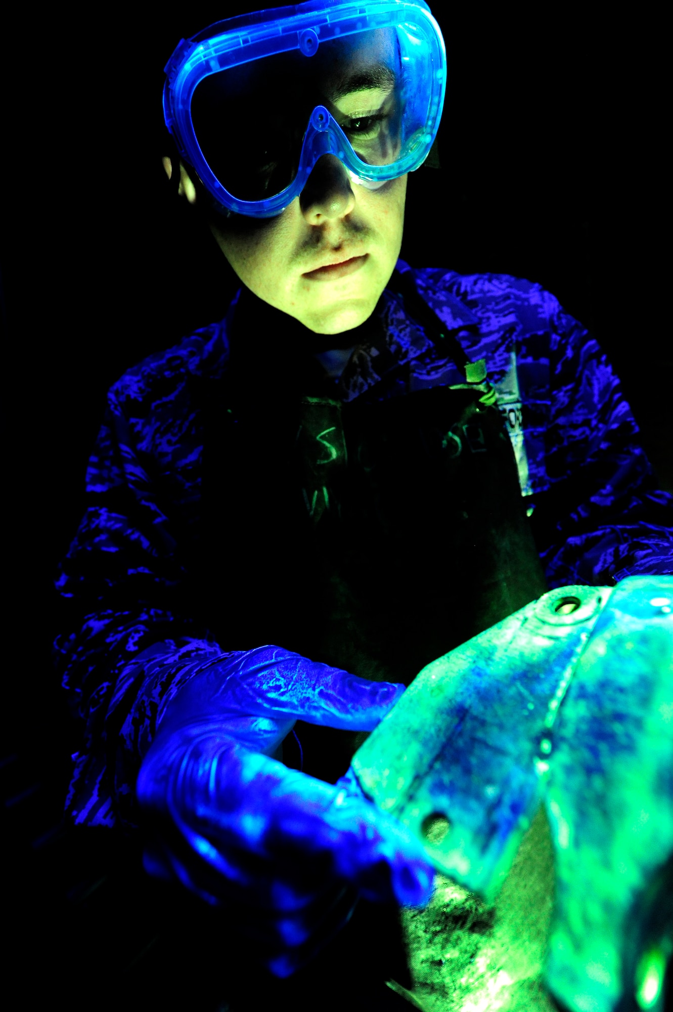 U.S. Air Force Staff Sgt. Nathan Lilly, 18th Equipment Maintenance Squadron Nondestructive Inspection technician, checks an aircraft part for cracks at the NDI shop on Kadena Air Base, Japan, Nov. 5, 2013. NDI uses multimillion-dollar equipment including an X-ray machine and a special dye that glows under a black light to inspect the integrity of roughly 500 parts a month. (U.S. Air Force photo by Senior Airman Maeson L. Elleman)