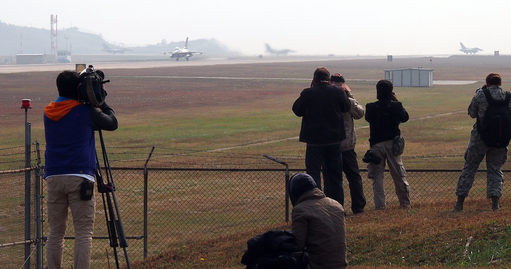 KUNSAN AIR BASE, Republic of Korea – Journalists attending the Exercise Max Thunder media day film and photograph Republic of Korea KF-16s taxiing for take-off Nov. 6, 2013. More than 20 local, national and international reporters and photographers came to Kunsan AB to see the exercise, which fosters bilateral aerial training between the Korea Air Power Team including the U.S. Air Force, Army and Marine Corps and the Republic of Korea Air Force. Exercise Max Thunder is part of a continuous exercise program to enhance interoperability between U.S. and ROK forces and highlights the longstanding military partnership, commitment and enduring friendship between the two nations. (U.S. Air Force photo by Tech. Sgt. Thomas J. Doscher)