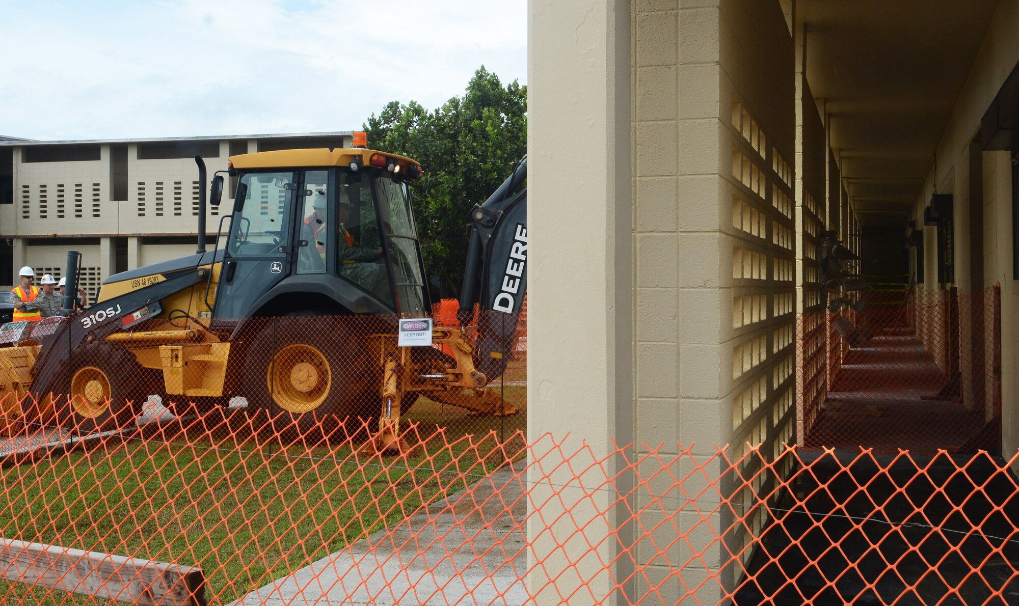 Brig. Gen. Steven Garland, 36th Wing commander, knocks down a wall with a backhoe, marking the beginning of Bldg. 21000’s demolition Nov. 5, 2013, on Andersen Air Force Base, Guam. The building is being demolished to make use of square footage in other buildings and save energy for the Air Force. (U.S. Air Force photo by Airman 1st Class Emily A. Bradley/Released)