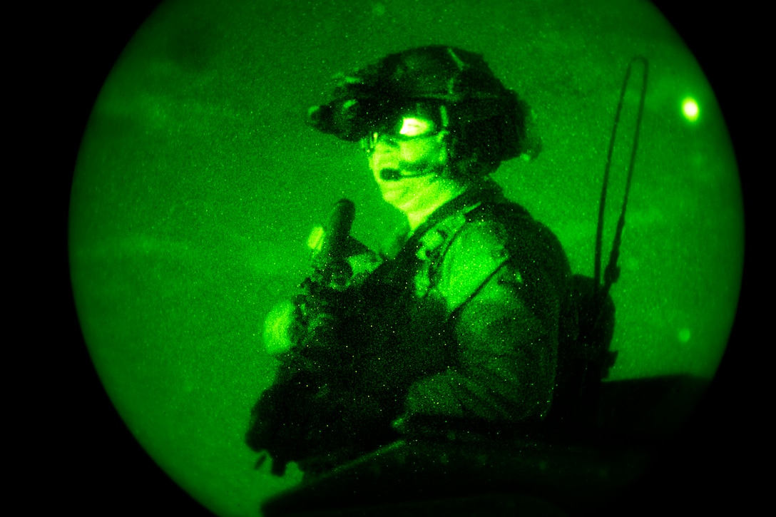 As seen through a night-vision device, an Army Special Forces member scans the fields during a training exercise on Eglin Range, Fla., Nov. 5, 2013.