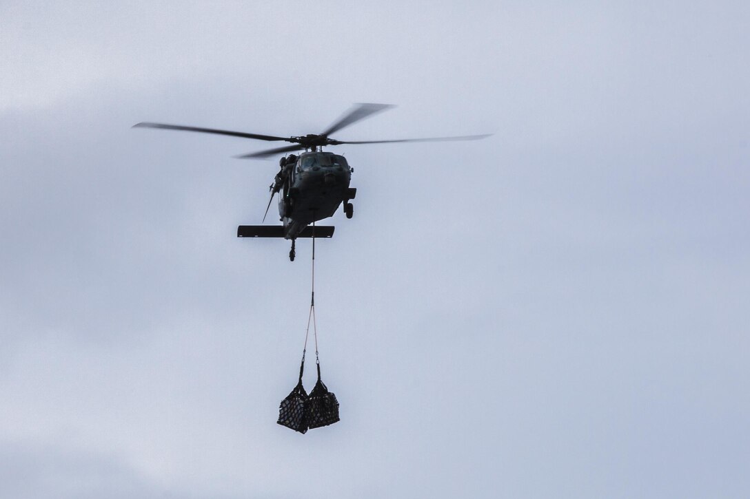 A U.S. Navy MH-60S Sea Hawk helicopter with Helicopter Sea Combat Squadron (HSC) 22 air lifts supplies from the USNS Robert E. Peary (T-AKE 5) dry cargo/ammunition ship to the USS Bataan (LHD 5) during a replenishment at sea off the East Coast Nov. 6, 2013. The 22nd MEU is currently taking part in the Amphibious Ready Group (ARG)/MEU Exercise in preparation for its scheduled 2014 deployment to the U.S. 5th and 6th Fleet areas of responsibility with the Bataan ARG as a sea-based, expeditionary crisis response force capable of conducting amphibious missions across the full range of military operations. (U.S. Marine Corps photo by Sgt. Austin Hazard/Released)