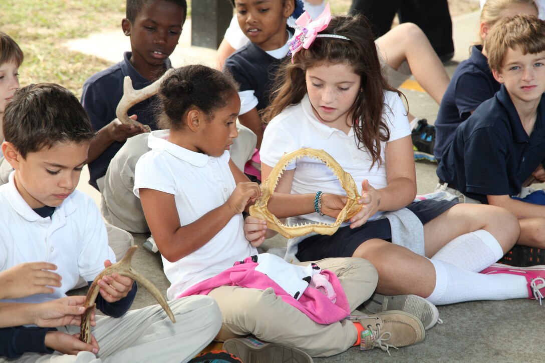 Children examine sharks teeth and other animal items to learn about habitat in Georgia's ecosystem, during a visit by the U.S. Army Corps of Engineers Savannah District at Marshpoint Elementary School, Nov. 5, 2013.