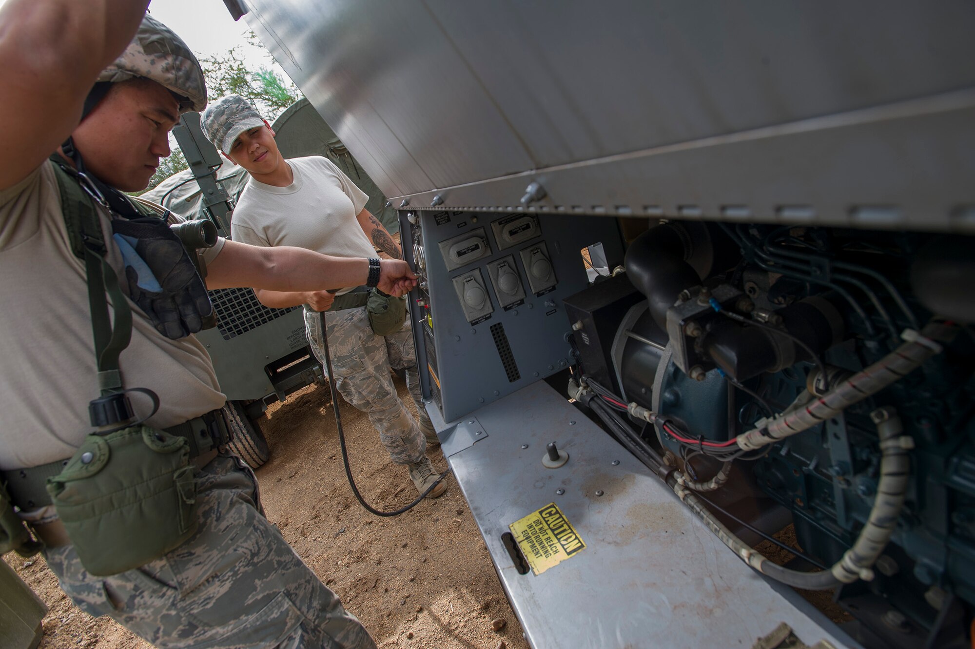Senior Airman Chu Hyurn, left, 154th Force Support Squadron fitness specialist, and Staff Sgt. Stephanie Esposito, 647th Force Support Squadron noncommissioned-officer-in-charge of store room, starts up a backup generator during an Operational Readiness Inspection at Joint Base Pearl Harbor-Hickam, Hawaii, Nov. 7. 2013. This inspections helps Airmen meet compliance and maintain mission readiness. (U.S. Air Force photo/Tech. Sgt. Jerome S. Tayborn)