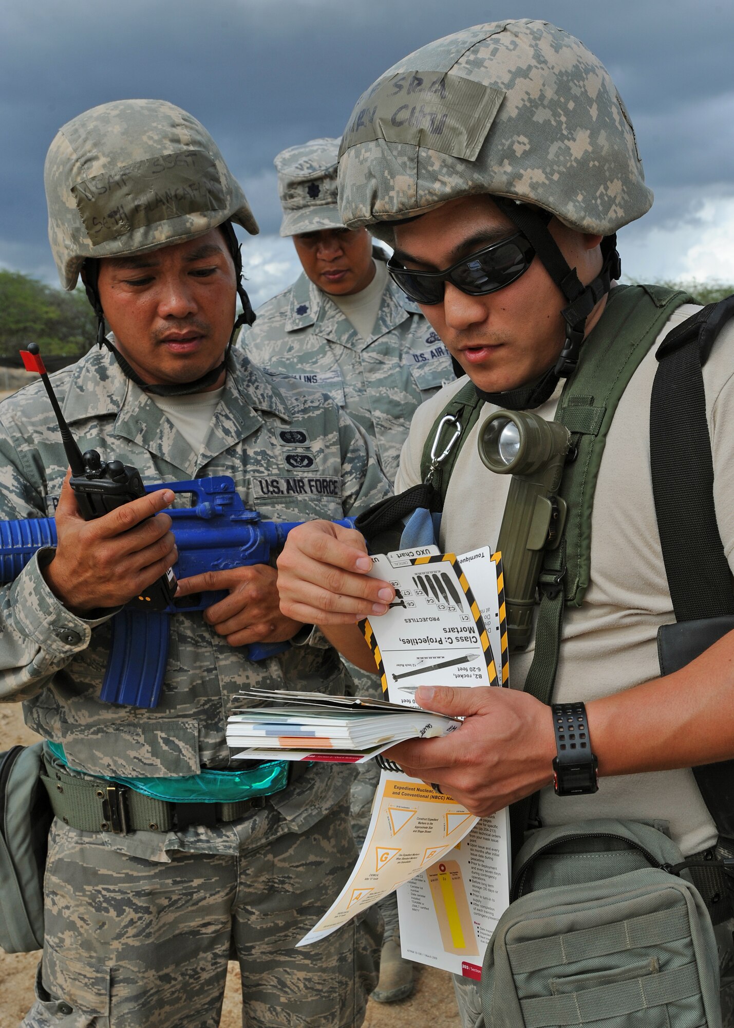Staff Sgt. Seth Blancuflor, left, and Senior Airman Chu Hyurn, right, from the 154th Force Support Squadron fitness specialists, prepare to radio in the location of simulated unexploded ordinance as Lt. Col. Sonya Collins, Pacific Air Forces Inspector General observes and evaluates their performance in a post attack reconnaissance sweep during an Operational Readiness Inspection at Joint Base Pearl Harbor-Hickam, Hawaii, Nov. 7. 2013. This inspection helps to evaluate personnel and equipment for mission effectiveness. (U.S. Air Force photo/Tech. Sgt. Jerome S. Tayborn)