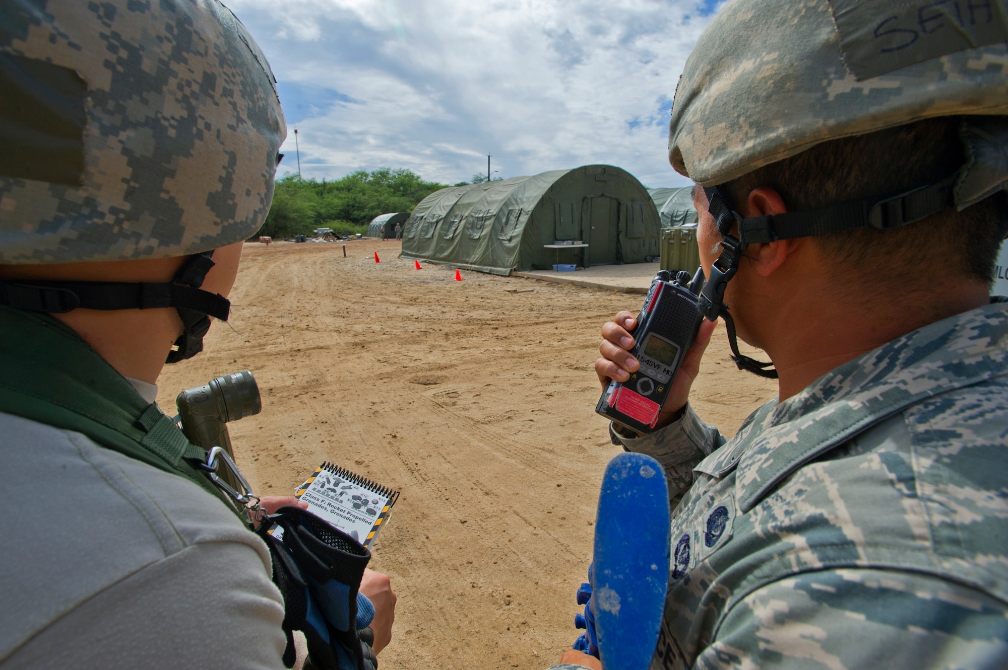 Senior Airman Chu Hyurn, left, and Staff Sgt. Seth Blancuflor, right, from the 154th Force Support Squadron fitness specialists, prepare to radio in the location of an unexploded ordinance in a simulated post attack reconnaissance sweep during an Operational Readiness Inspection at Joint Base Pearl Harbor-Hickam, Hawaii, Nov. 7. 2013. This inspection’s participants were tested on their ability to properly react to a broad range of scenarios and environmental conditions. (U.S. Air Force photo/Tech. Sgt. Jerome S. Tayborn)