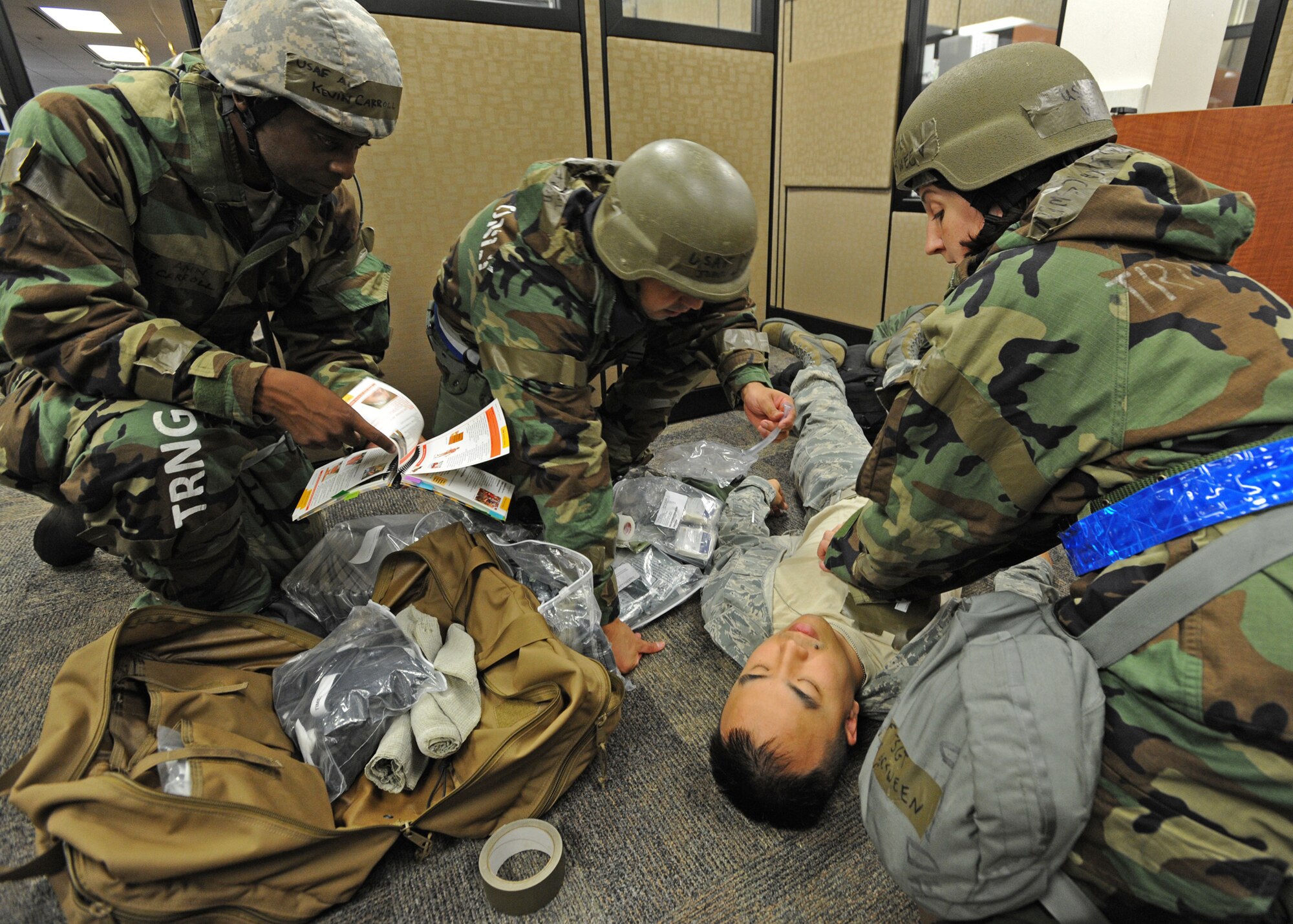 Members from 15th Comptroller Squadron and 154th Comptroller Flight administer self-aid buddy care procedures on a downed Airman at the military pay and finance building, during an Operational Readiness Inspection at Joint Base Pearl Harbor-Hickam, Hawaii, Nov. 7. 2013. This inspection demonstrates the effective use of Total Force Integration by including both 15th Wing and 154th Hawaii Air National Guard Airmen working side-by-side to accomplish the mission. (U.S. Air Force photo/Tech. Sgt. Jerome S. Tayborn)