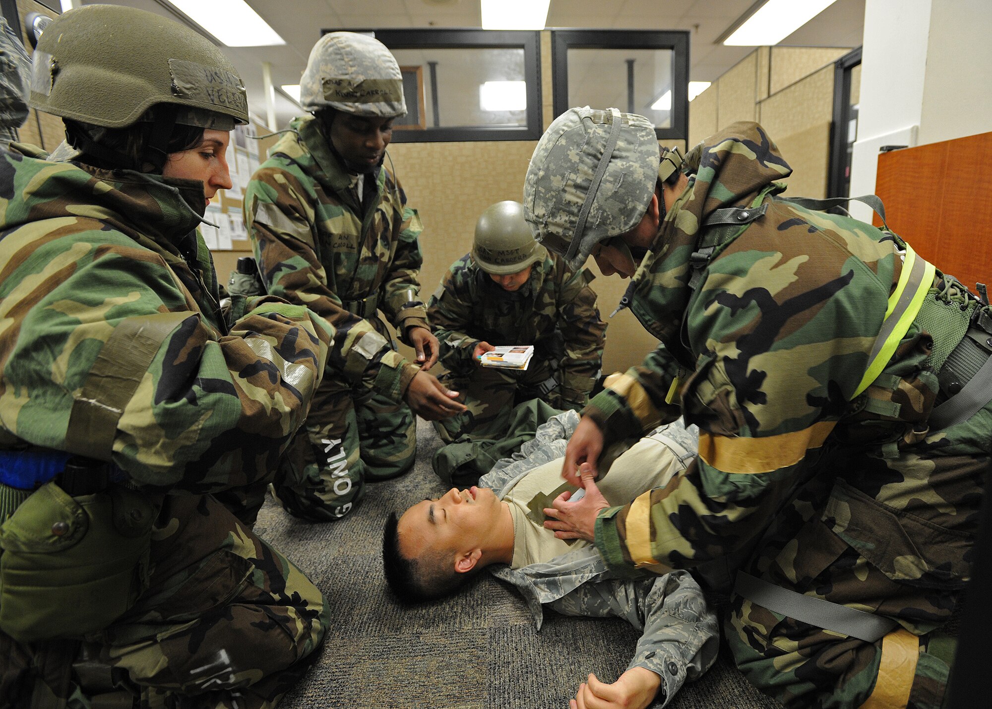 Members from 15th Comptroller Squadron and 154th Comptroller Flight demonstrate self-aid buddy care procedures on a downed Airman at the military pay and finance building, during an Operational Readiness Inspection at Joint Base Pearl Harbor-Hickam, Hawaii, Nov. 7. 2013. This inspection demonstrates the effective use of Total Force Integration by including both 15th Wing and 154th Hawaii Air National Guard Airmen working side-by-side to accomplish the mission. (U.S. Air Force photo/Tech. Sgt. Jerome S. Tayborn)