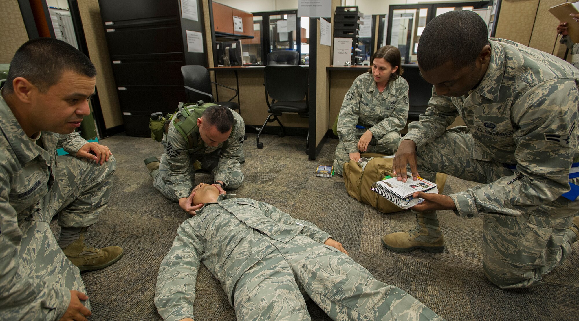 Members from 15th Wing Comptroller Squadron and 154th Comptroller Flight demonstrate self-aid buddy care procedures on a downed Airman at the military pay and finance building, during an Operational Readiness Inspection at Joint Base Pearl Harbor-Hickam, Hawaii, Nov. 7. 2013. This inspection provides realistic training using scenarios that allow integration between the 15th Wing and 154th Hawaii Air National Guard. (U.S. Air Force photo/Tech. Sgt. Jerome S. Tayborn)
