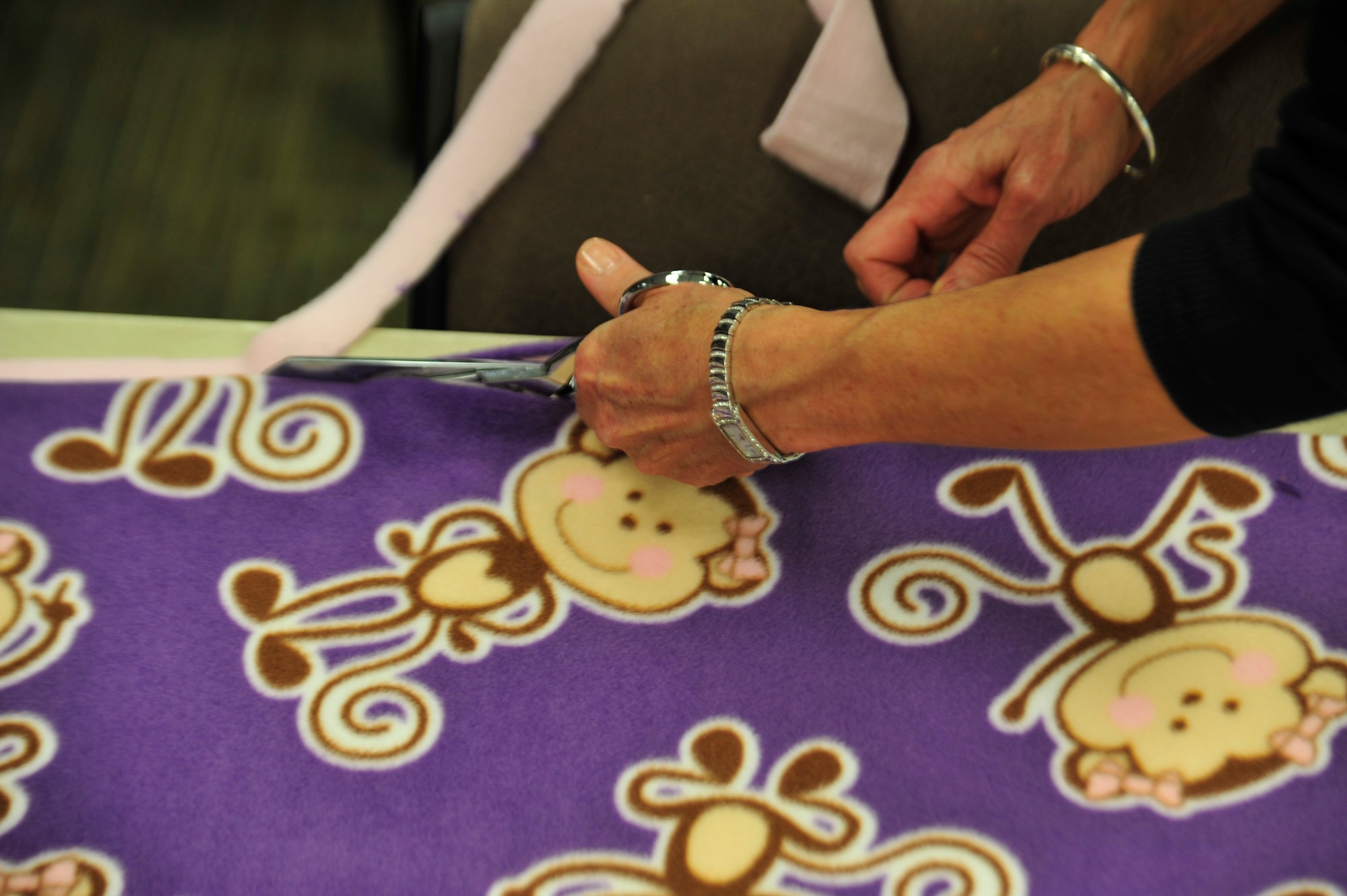 A volunteer cuts fleece to make a blanket Nov. 7, 2013, at the chapel on Buckley Air Force Base, Colo. The Women’s Empowerment Group, Buckley Spouses and Buckley Women’s Ministry, along with women from all over the base, joined together to create blankets to donate to the Comitis Crisis Center in Aurora, Colo. (U.S. Air Force photo by Airman 1st Class Samantha Saulsbury/Released)
