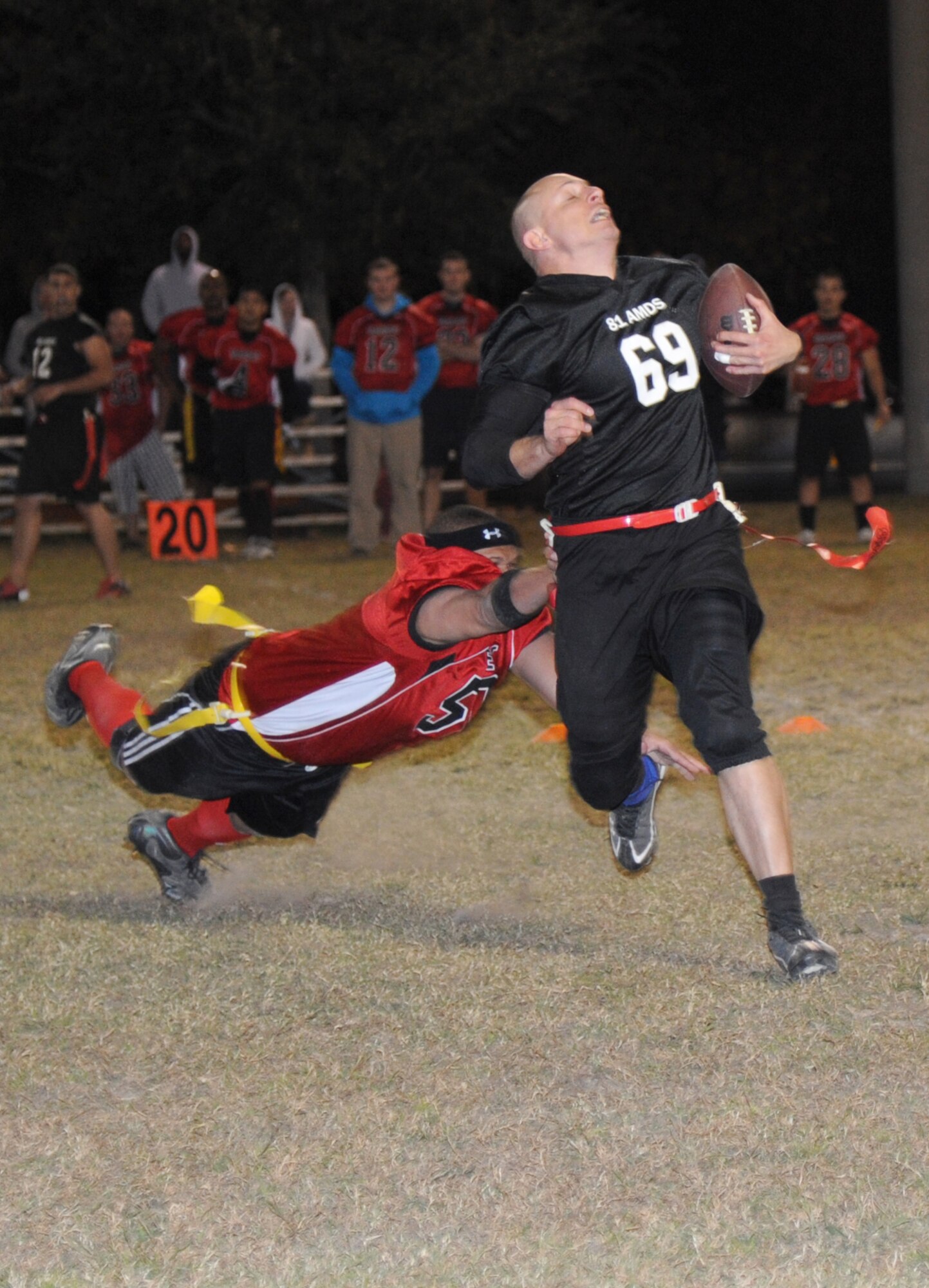 Carlton Sells, Keesler Marine Detachment, stretches out for the flag of Christopher Judy, 81st Aerospace Medicine Squadron, as he runs the ball during the intramural flag football championship game Nov. 7, 2013, at Keesler Air Force Base, Miss.  The Marines defeated 81st AMDS, 26-14.  (U.S. Air Force photo by Kemberly Groue)