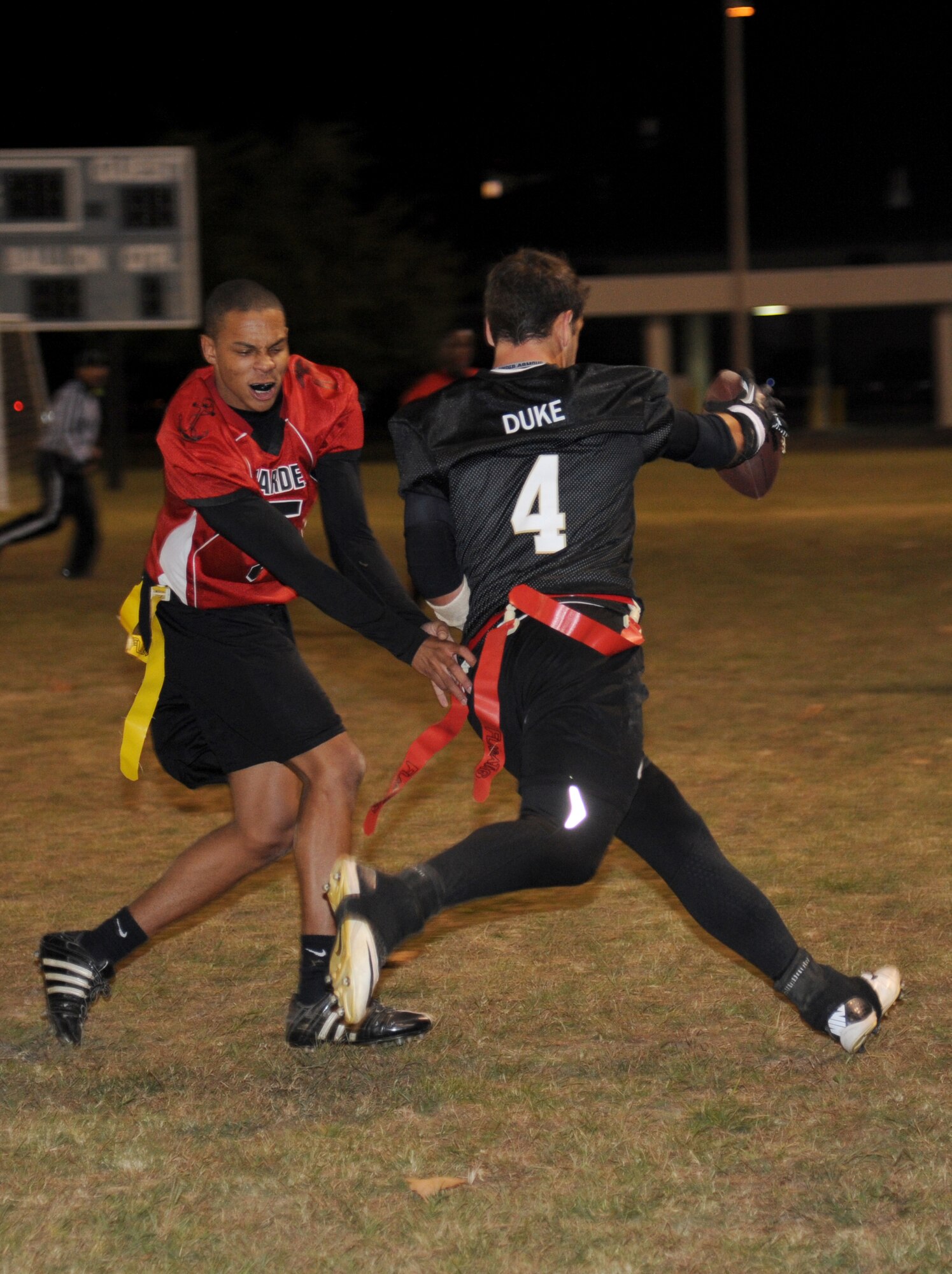 Jahel Carter, Keesler Marine Detachment, grabs the flag of Andrew Dailey, 81st Aerospace Medicine Squadron quarterback, as he attempts to run pass him during the intramural flag football championship game Nov. 7, 2013, at Keesler Air Force Base, Miss.  The Marines defeated 81st AMDS, 26-14.  (U.S. Air Force photo by Kemberly Groue)