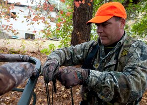 Hunter Eric Brazzale sets up his high-seat before hunting at Fort Eustis, Va., Nov. 5, 2013.  Hunters on Joint Base Langley-Eustis are required to use a harness and other safety equipment when hunting in a high-seat or tree stand.  (U.S. Air Force photo by Shaun Eagan/Released)  