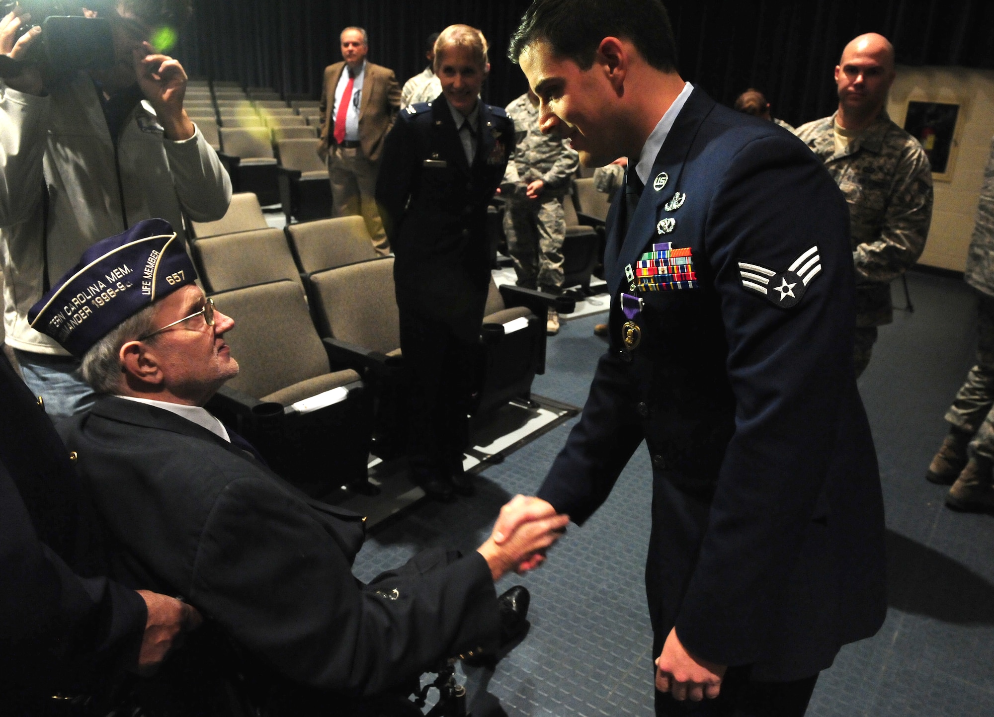 U.S. Air Force Senior Airman Justin Beasley, 4th Civil Engineer Squadron explosive ordnance disposal technician, shakes hands with Carlyle Waters, Military Order of the Purple Heart Chapter 657 member, after a Purple Heart ceremony at Seymour Johnson Air Force Base, N.C., Nov. 8, 2013.  Waters and two other members of the chapter attended the ceremony to welcome Beasley to their Purple Heart family.  Beasley was awarded the medal for injuries he sustained in action, including traumatic brain injury and hearing loss.  (U.S. Air Force photo by Airman 1st Class Brittain Crolley)