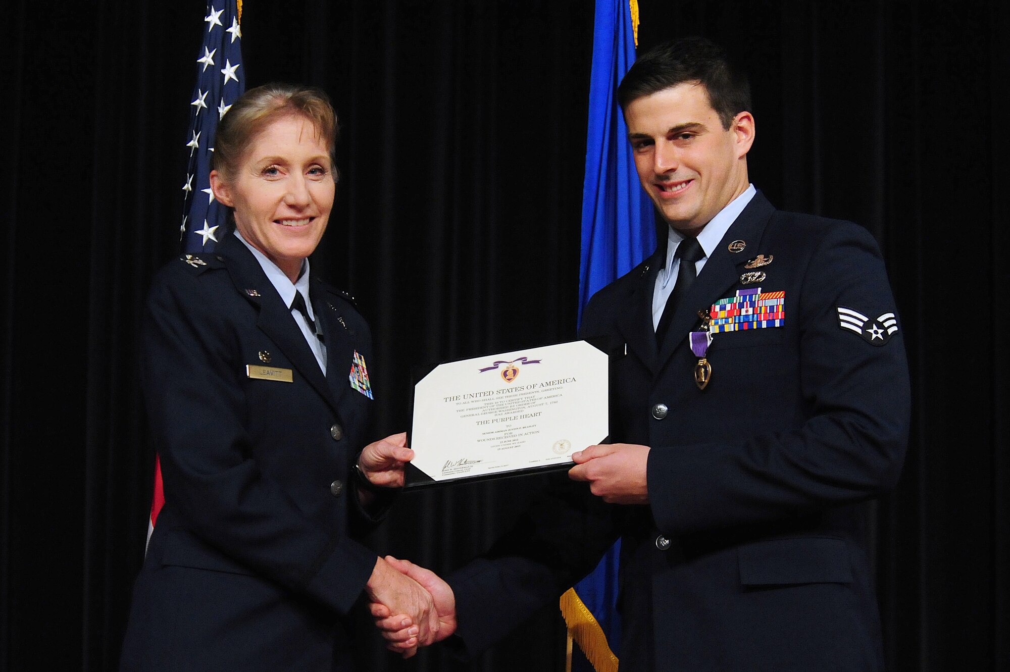 U.S. Air Force Col. Jeannie Leavitt, 4th Fighter Wing commander, presents Senior Airman Justin Beasley, 4th Civil Engineer Squadron explosive ordnance disposal technician, with his Purple Heart citation during a ceremony at Seymour Johnson Air Force Base, N.C., Nov. 8, 2013.  Beasley suffered a traumatic brain injury after his vehicle was attacked during a recent deployment to Afghanistan.  (U.S. Air Force photo by Airman 1st Class Brittain Crolley)