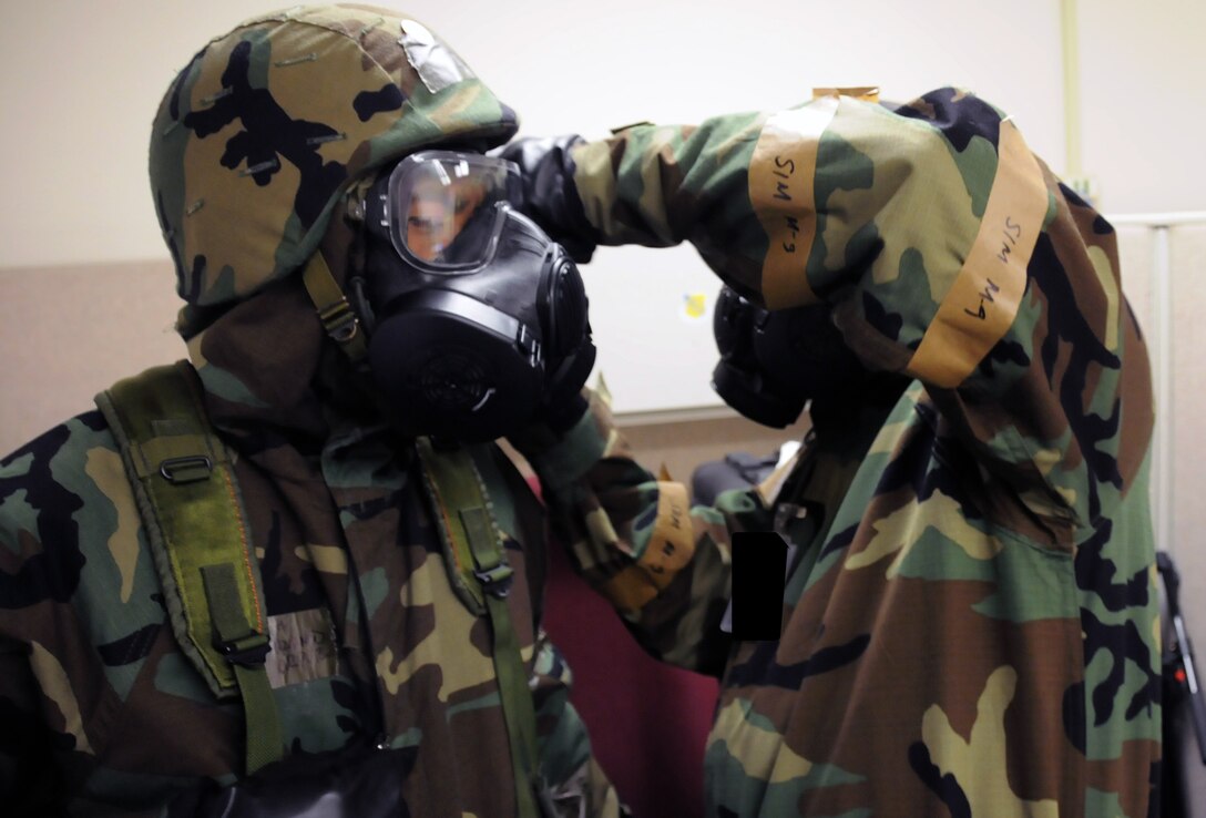 Airmen don the gas mask and other protective equipment during an Operational Readiness Inspection at Joint Base Pearl Harbor-Hickam, Hawaii, Nov. 7, 2013. This inspection demonstrates the effective use of Total Force Integration by including both 15th Wing and 154th Hawaii Air National Guard Airmen working side-by-side to accomplish the mission. (U.S. Air Force photo/Tech. Sgt. Michelle Thomas)