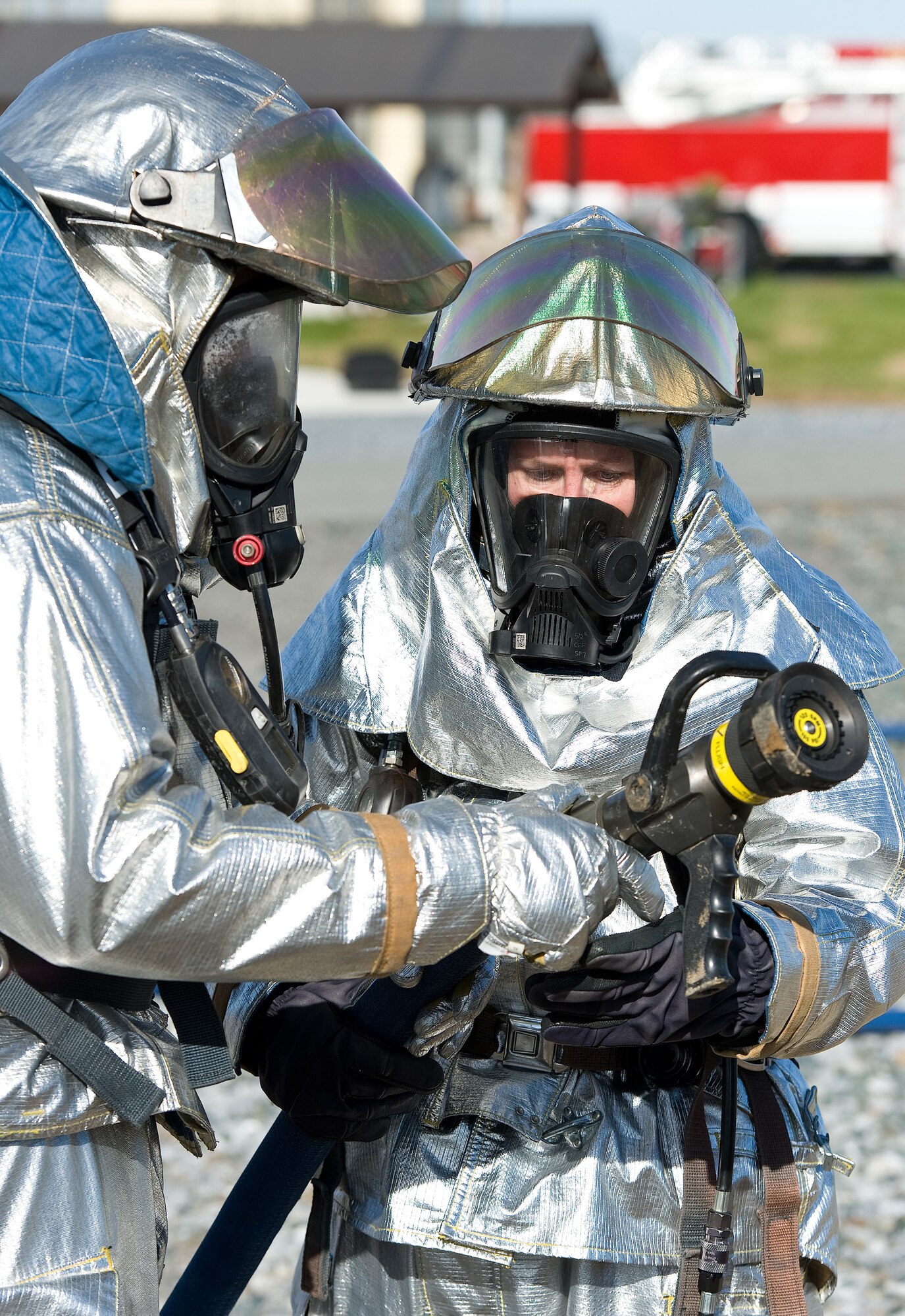 Col. Gretchen Wiltse, 512th Mission Support Group commander, right, receives training on fog nozzle operations from Master Sgt. Curtis Waters, 512th Civil Engineer Squadron Fire Department deputy chief, Nov. 4, 2013, at the fire training area on Dover Air Force Base, Del. Wiltse was part of a two-person fire attack crew for a simulated aircraft fire. (U.S. Air Force photo/Roland Balik)