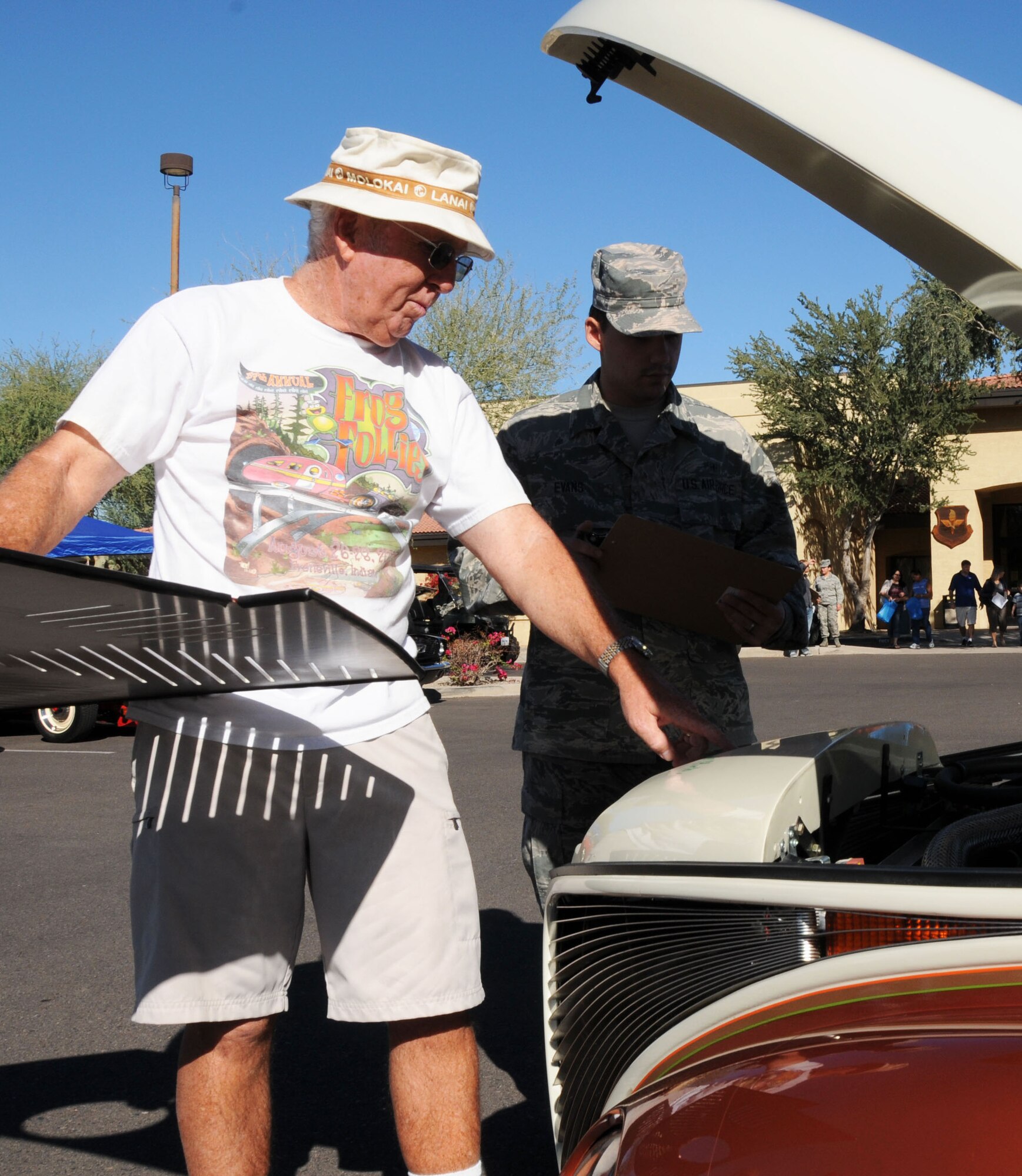 Phil Murray, retired Navy captain and first-place winner of the car show, explains the details of his 1939 Studebaker pickup to Airman 1st Class David Evans, 56th Dental Squadron and a judge for the car show. Trophies were handed out to the top three winners during Retiree Appreciation Day. (U.S. Air Force photo/Tech. Sgt. Louis Vega Jr.)