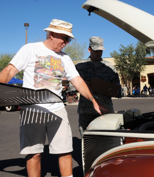 Phil Murray, retired Navy captain and first-place winner of the car show, explains the details of his 1939 Studebaker pickup to Airman 1st Class David Evans, 56th Dental Squadron and a judge for the car show. Trophies were handed out to the top three winners during Retiree Appreciation Day. (U.S. Air Force photo/Tech. Sgt. Louis Vega Jr.)