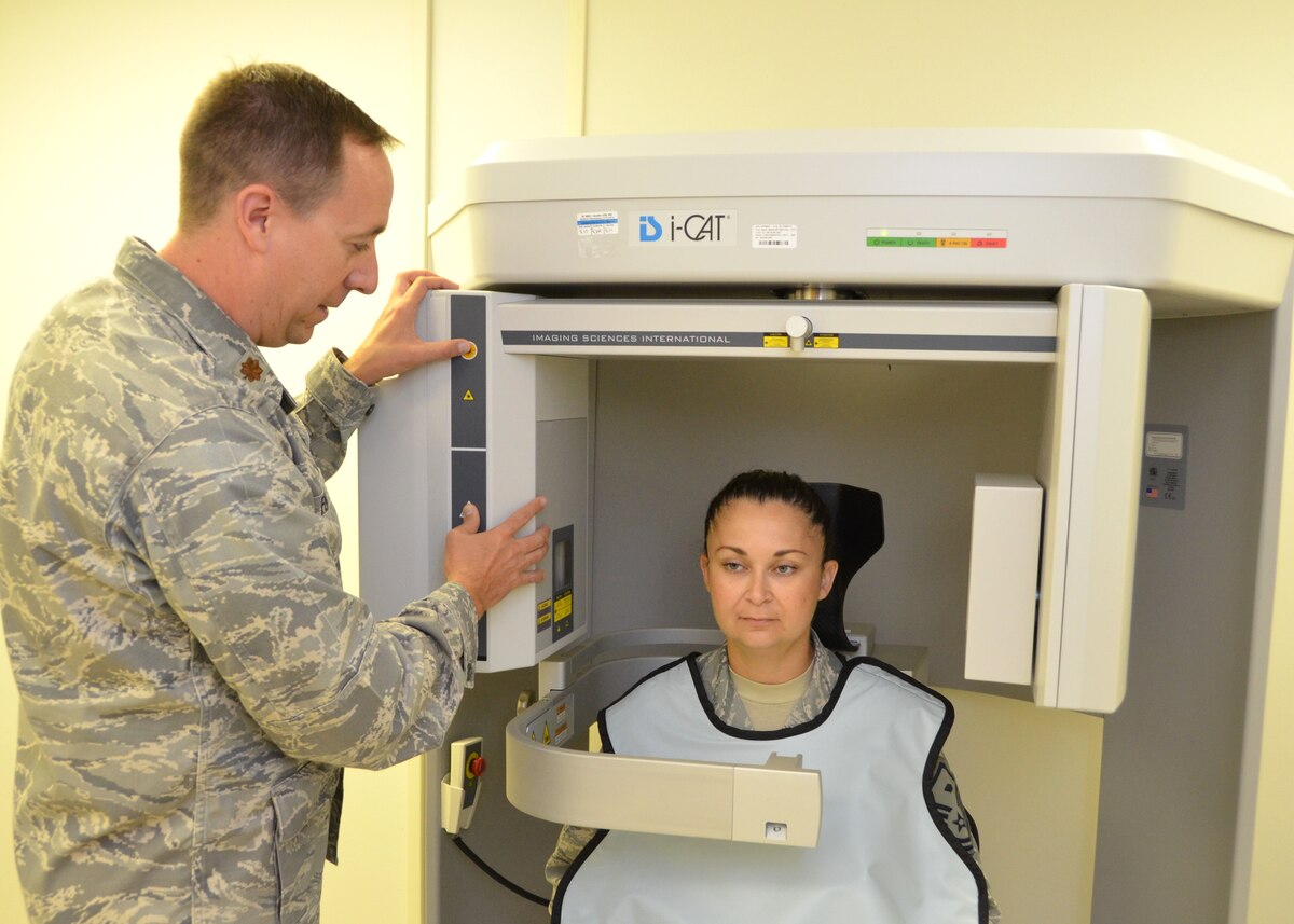 Maj. (Dr.) Jeffrey Ford positions simulated patient Master Sgt. Christina Tinsley for a 3D x-ray using the iCAT cone-beam computed tomography equipment.  Tinsley is 81st Dental Squadron first sergeant. (U.S. Air Force photo by Steve Pivnick)