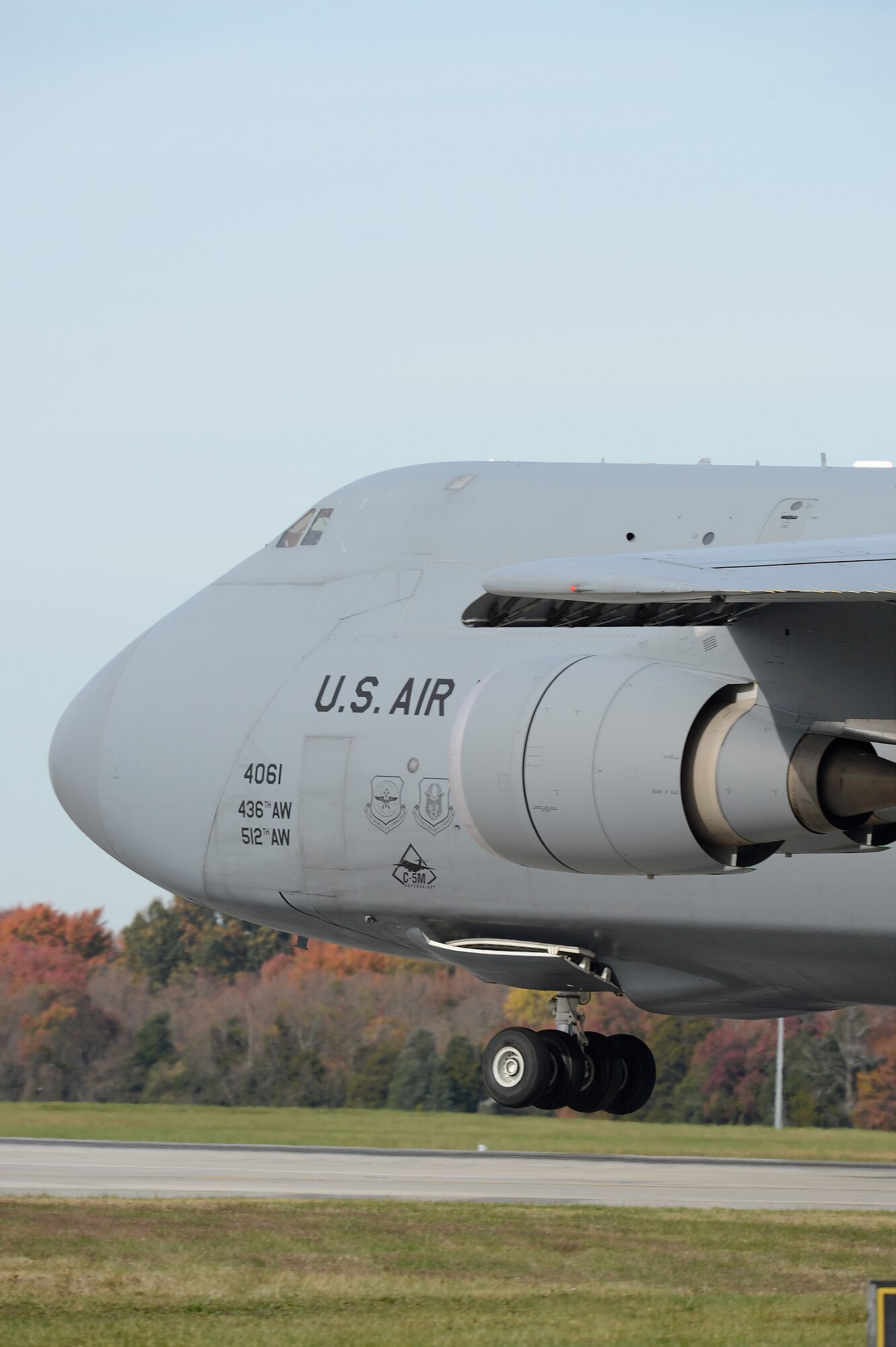 A C-5M Super Galaxy from the 9th Airlift Squadron, 436th Airlift Wing, is seen on final approach  as a crew from the 9th Airlift Squadron conducts aircrew proficiency training Nov. 4, 2013, at Dover Air Force Base, Del. Fall colors can be seen on the trees behind the landing aircraft. (U.S. Air Force photo/Greg L. Davis)