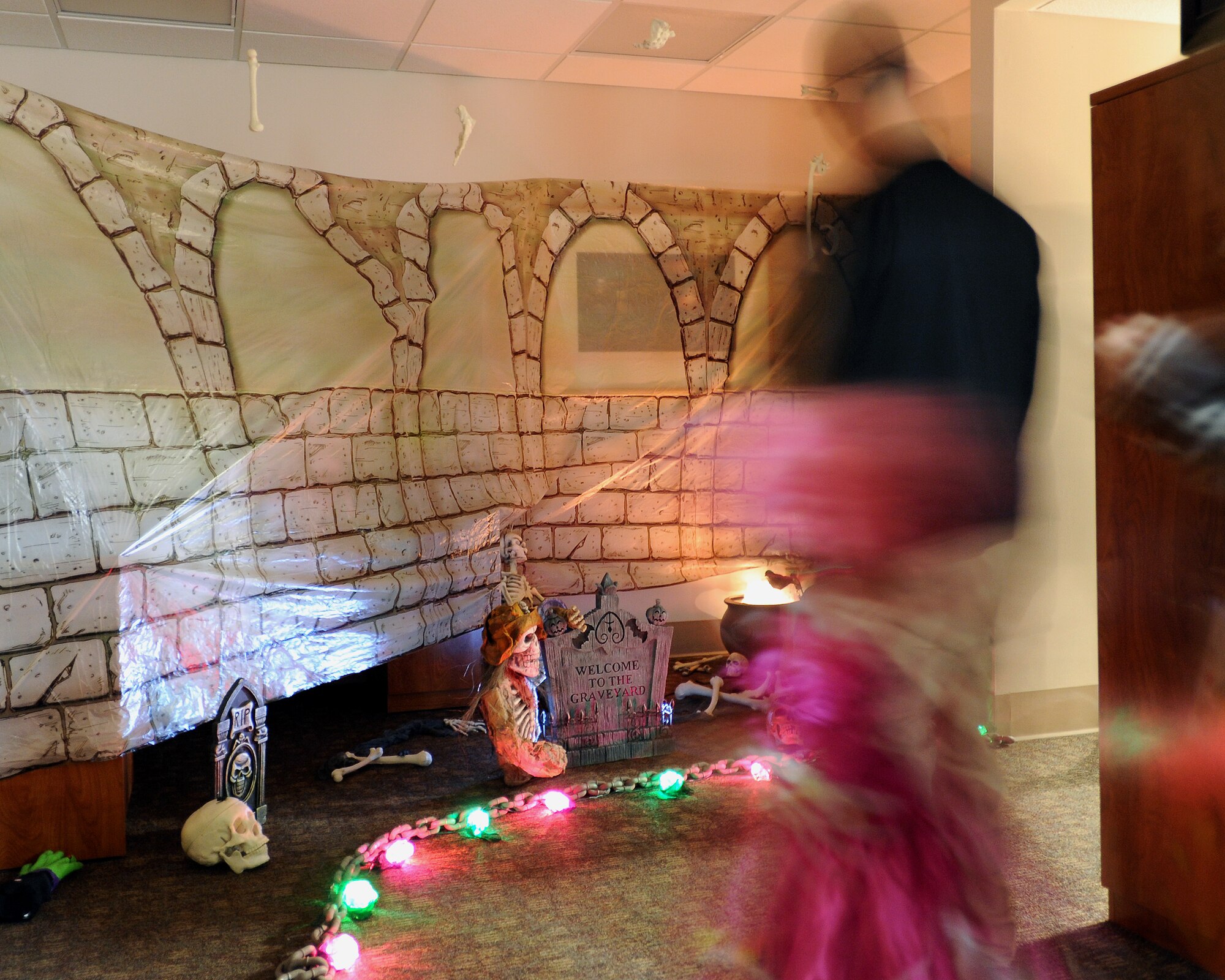 Trick-or-treaters and their families walk through a haunted hallway in the 319th Medical Group during the annual indoor trick-or-treating event Oct. 31, 2013, on Grand Forks Air Force Base, N.D. The 319th Medical Group hosts trick-or-treating every year as a way for children and families to enjoy the holiday. (U.S. Air Force Photo/Airman 1st Class Zachiah Roberson)