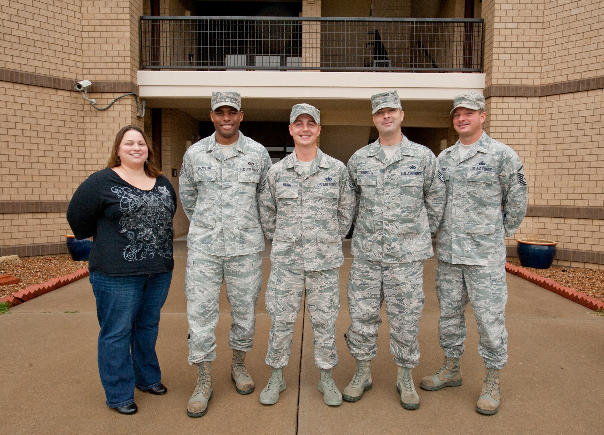 (Left to right) Shanna Dempsey, 22nd Civil Engineer Squadron housing manager, Staff Sgt. Marcus Drayton, 22nd CES Airman dorm leader, Tech. Sgt. Andrew Hunn, 22nd CES ADL, Staff Sgt. Gregory L. Thompson, 22nd CES ADL, and Master Sgt. Bradley Gifford, 22nd CES unaccompanied housing superintendent, pose in front of Dorm 342 Nov. 6, 2013, at McConnell Air Force Base, Kan. This group manages the three unaccompanied Airmen dormitories on base, which house more than 400 Airmen. (U.S. Air Force photo/Airman 1st Class Victor J. Caputo)