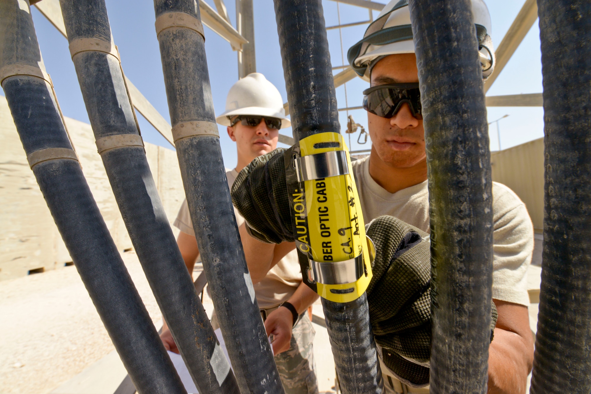 Senior Airman Wong Ly labels an antenna cable at the 379th Air Expeditionary Wing in Southwest Asia, Oct. 30, 2013. Cables are labeled to track communication wire routes from the antenna tower to a radio control switch. Ly is a 379th Expeditionary Communications Squadron cable and antenna maintainer deployed from Kadena Air Base Japan and a native of Hilo, Hawaii. (U.S. Air Force photo/Tech. Sgt. Joselito Aribuabo)
