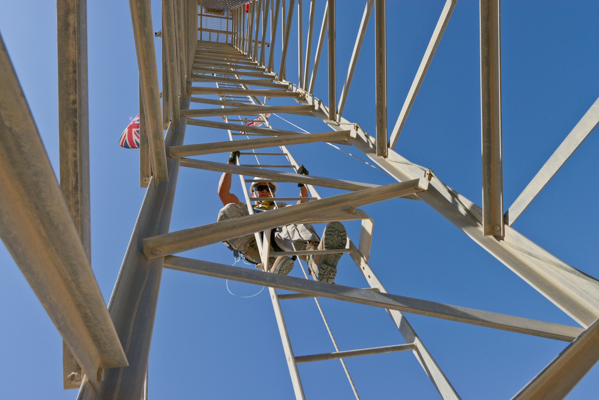 Senior Airman Wong Ly climbs down an antenna tower at the 379th Air Expeditionary Wing in Southwest Asia, Oct. 30, 2013. Cable maintainers perform preventive maintenance inspections on antennas every six months. Ly is a 379th Expeditionary Communications Squadron cable and antenna maintainer deployed from Kadena Air Base Japan and a native of Hilo, Hawaii. (U.S. Air Force photo/Tech. Sgt. Joselito Aribuabo)