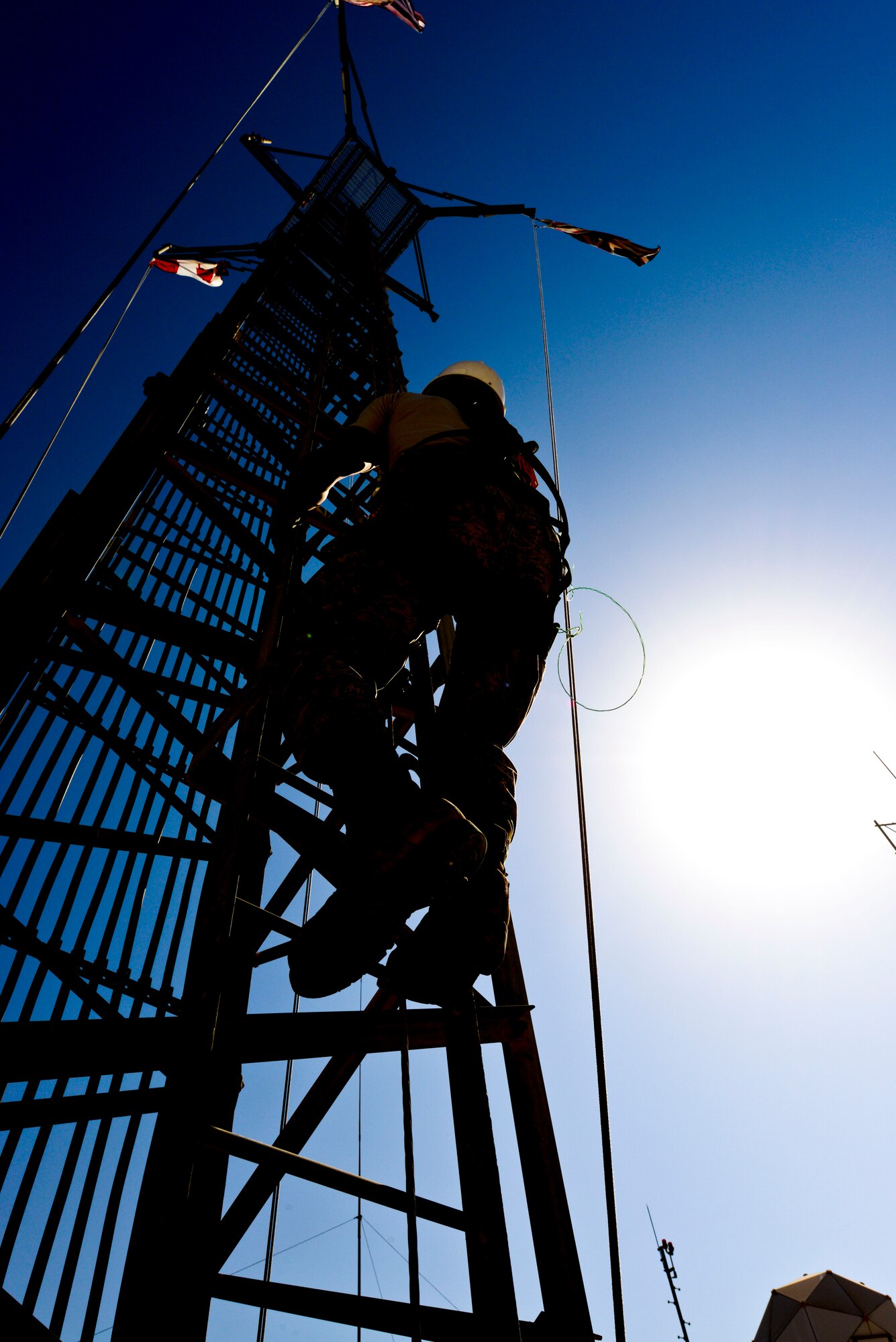 Senior Airman Wong Ly climbs an antenna tower at the 379th Air Expeditionary Wing in Southwest Asia, Oct. 30, 2013. Cable maintainers perform preventive maintenance inspections on antennas every six months. Ly is a 379th Expeditionary Communications Squadron cable and antenna maintainer deployed from Kadena Air Base Japan and a native of Hilo, Hawaii. (U.S. Air Force photo/Tech. Sgt. Joselito Aribuabo)