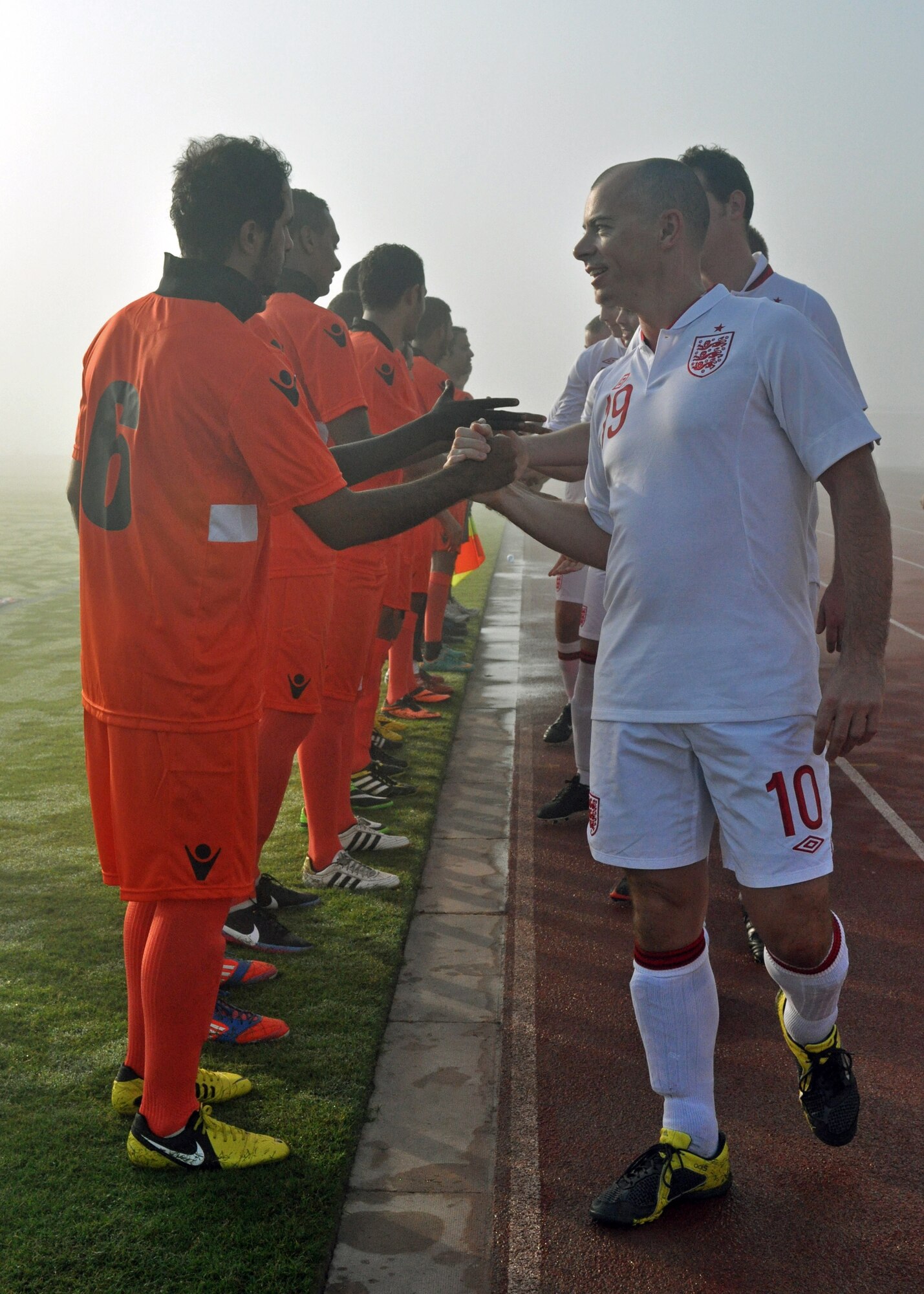 Team members from the host nation air force and Royal Air Force shake hands before the Friendship Games soccer tournament at the 379th Air Expeditionary Wing in Southwest Asia Oct. 27, 2013. The games were held at the local military compound’s soccer stadium and hosted by the host nation base commander Brig. Gen. Abdulla Jassim Al Meraikhi. (U.S. Air Force photo/1st Lt. Susan Harrington)