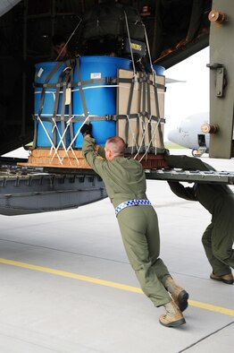 Airmen from the 37th Airlift Squadron load a pallet onto a C-130J Super Hercules to be dropped for equipment testing during a theater security cooperation event, Oct. 24, 2013, Powidz Air Transport Base, Poland. Airmen from Ramstein Air Base, Germany had a unique opportunity to work hand-in-hand with their Polish counterparts during this event. (U.S. Air Force photo/Senior Airman Hailey Haux)