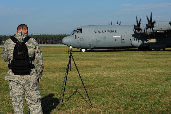 Master Sgt. Ben Barnett, 435th Contingency Response Group landing zone operations, communicates with the pilots of a C-130J Super Hercules during grass landing training, Oct. 23, 2013, Powidz Air Transport Base, Poland. Practicing grass landings is an essential part of staying mission ready for pilots. Grass landings occur when there is no constructed runway for aircraft to land in a required area.  (U.S. Air Force photo/Senior Airman Hailey Haux)