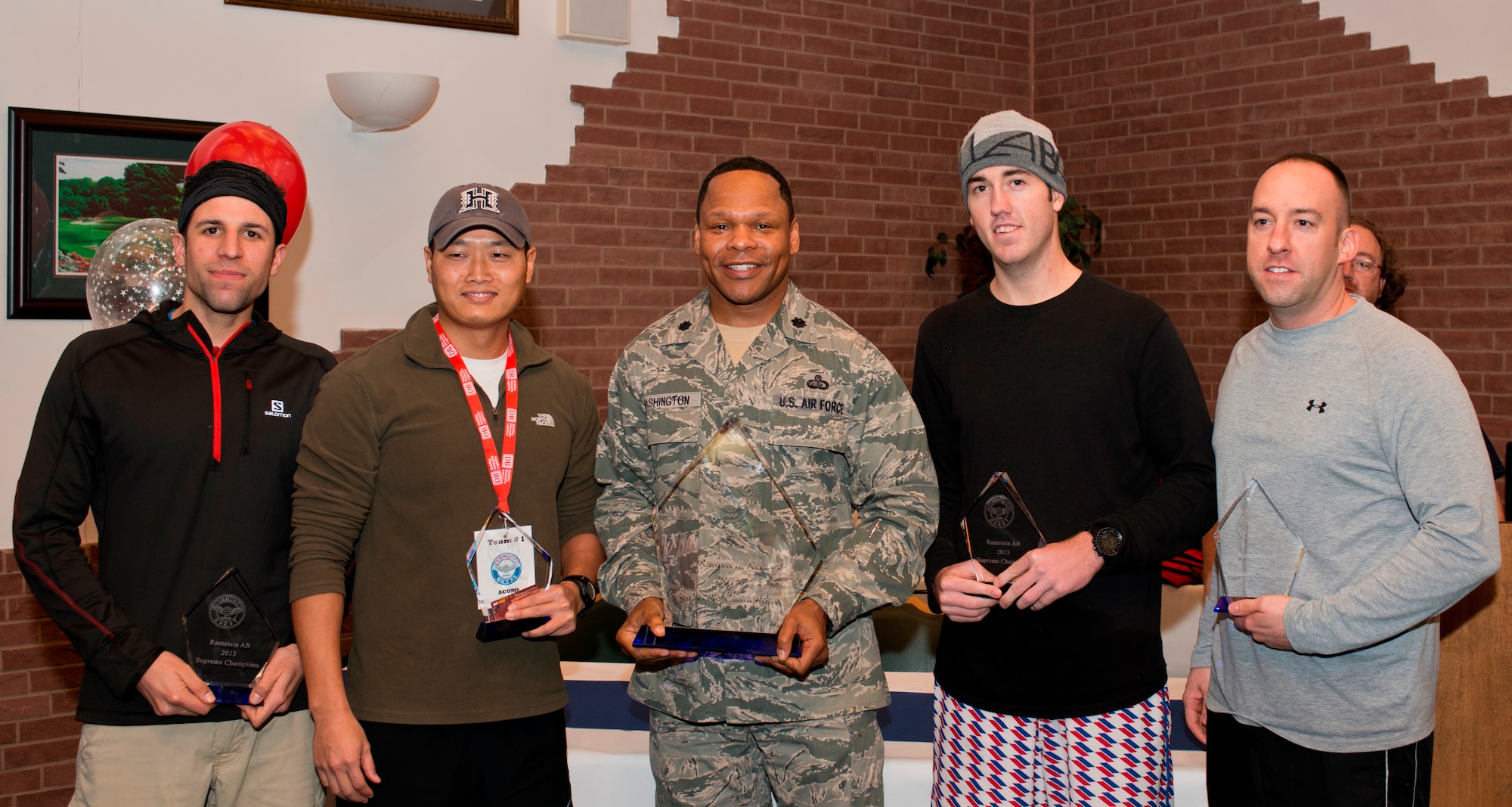 Lt. Col. Keithen Washington, 86th Force Support Squadron commander, presents the 603rd Air Communications Squadron Community Quest team the winning trophy, Nov. 6, 2013, Ramstein Air Base, Germany. While increasing camaraderie within the twelve teams the Community Quest also promoted the different facilities the 86th Force Support Squadron has to offer. (U.S. Air Force photo/Senior Airman Jonathan Stefanko)
