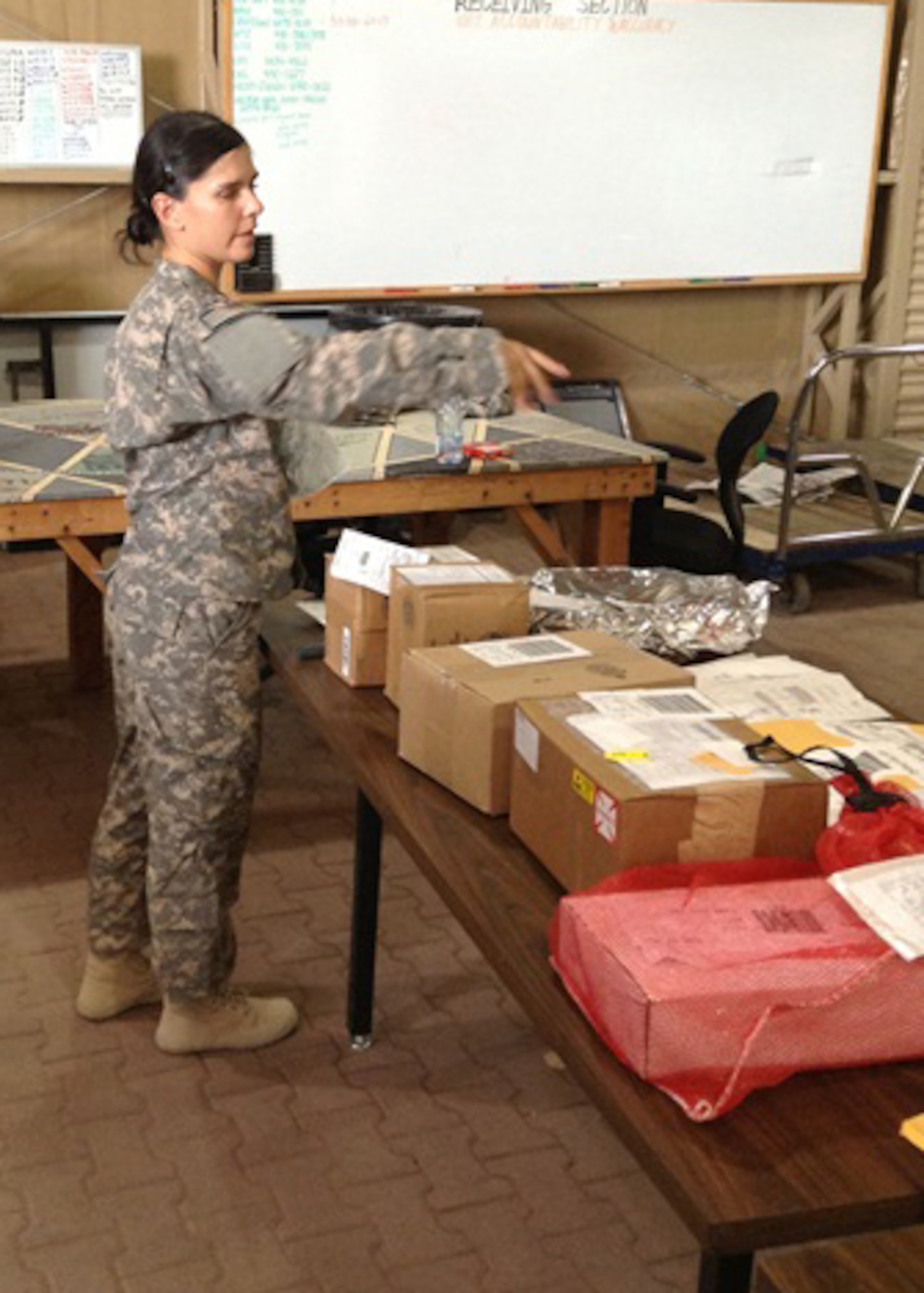 Sgt. Monica Maciel, Foxtrot Company, 1st Battalion 44th Air Defense Artillery Regiment, directs the workflow as a shipment of goods arrives at the Supply Support Activities warehouse at an undisclosed location in Southwest Asia, Sept. 21, 2013. Foxtrot Co.’s SSA recently received the Department of the Army Supply Excellence Award. (U.S. Army photo/2nd Lt. Spencer Ferrebee)