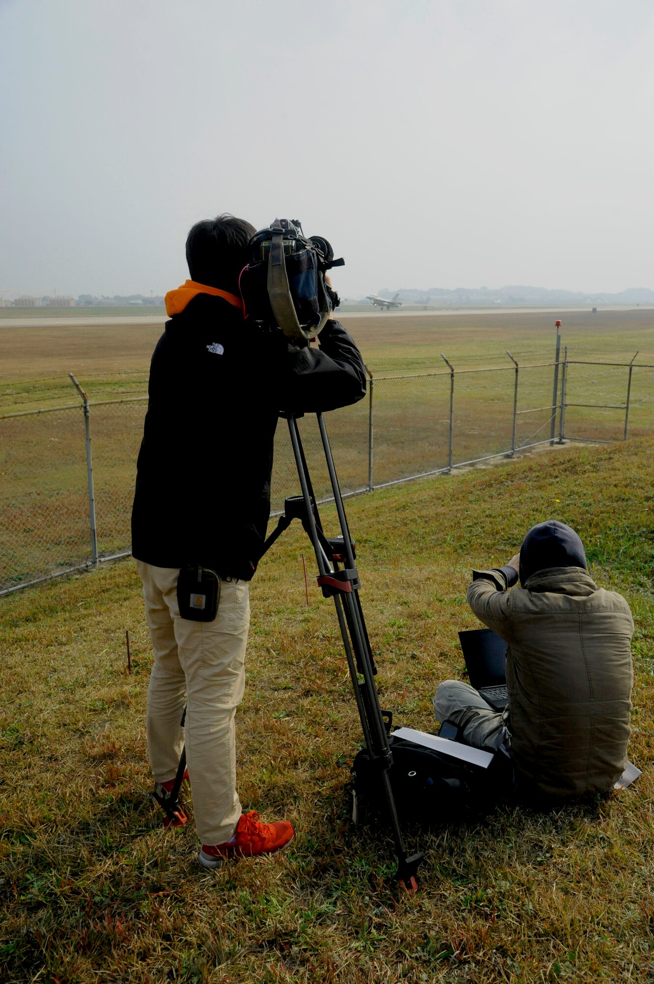 Media gathers near the flight line to document an 8th Fighter Wing F-16 Fighting Falcon take-off during the Max Thunder exercise at Kunsan Air Base, Republic of Korea, Nov. 6, 2013. Hosting members of the international media community enhances a global understanding and awareness of exercises like Max Thunder that demonstrate joint service capabilities. (U.S. Air Force photo by Staff Sgt. Jessica Haas/Released)